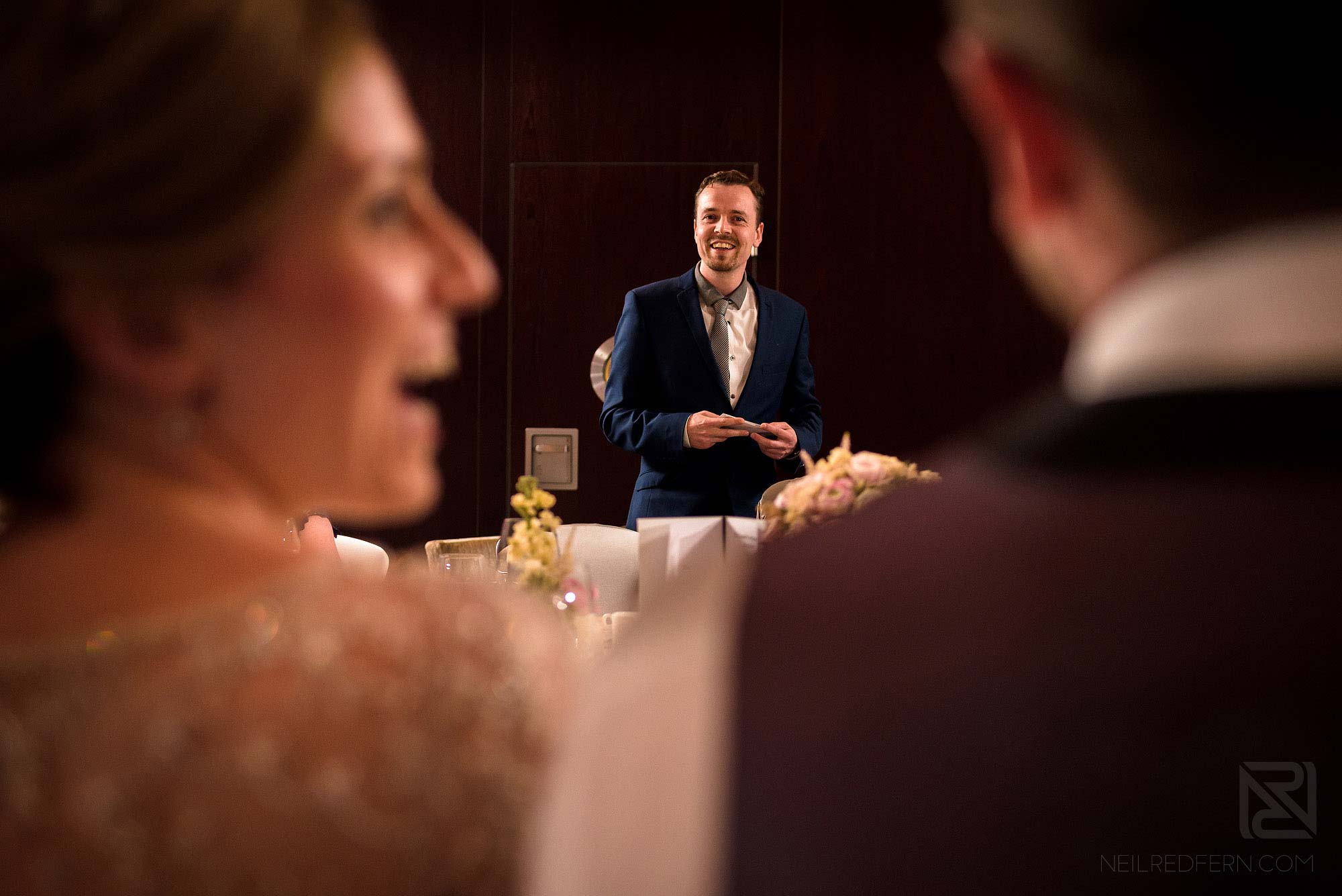 bride and groom laughing during best man's speech