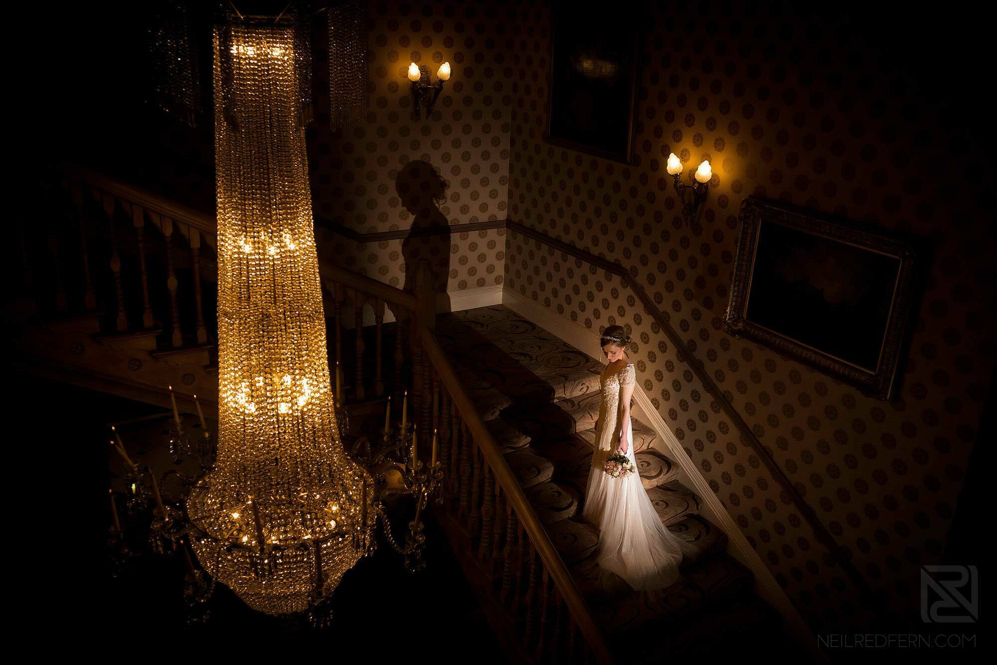 portrait of bride next to large chandelier in Chester Grosvenor