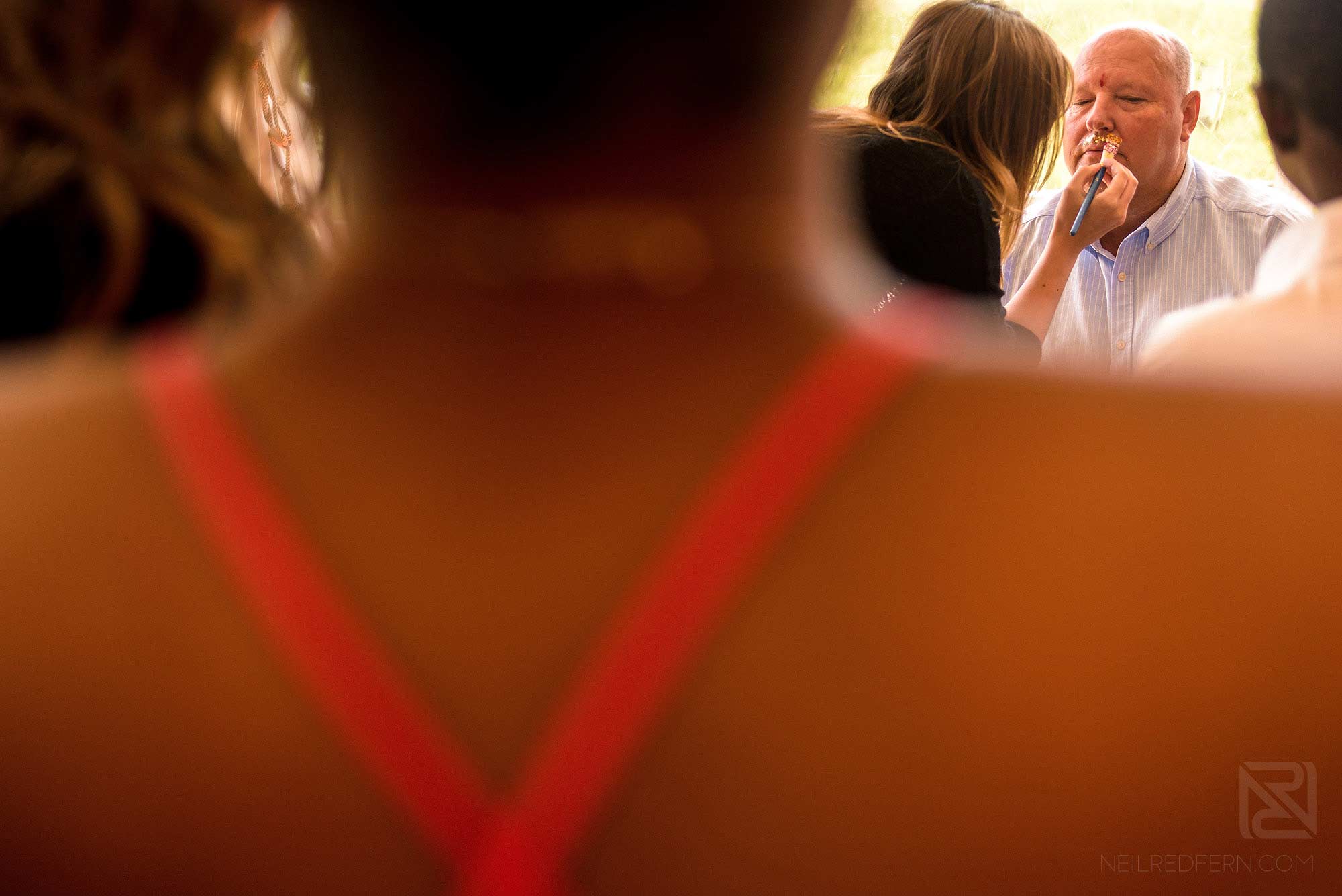 make-up artist putting glitter on wedding guest
