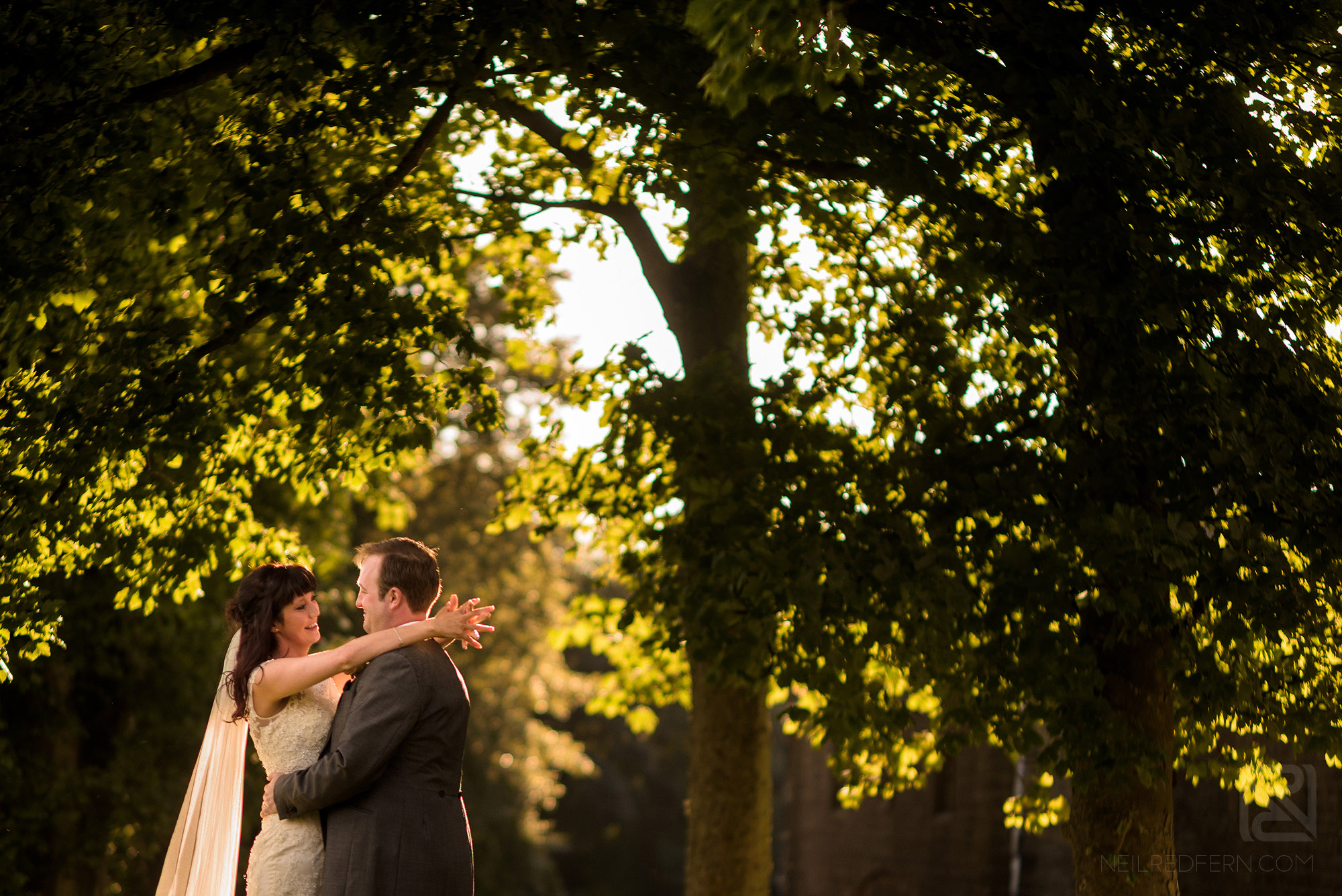 happy newlyweds in front of trees