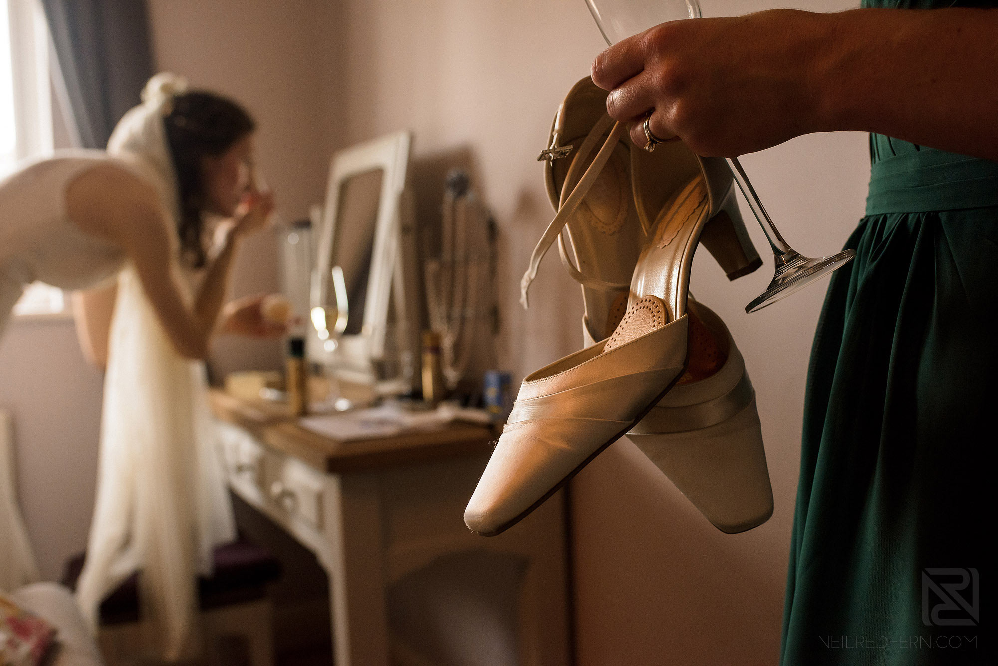 bridesmaid holding shoes