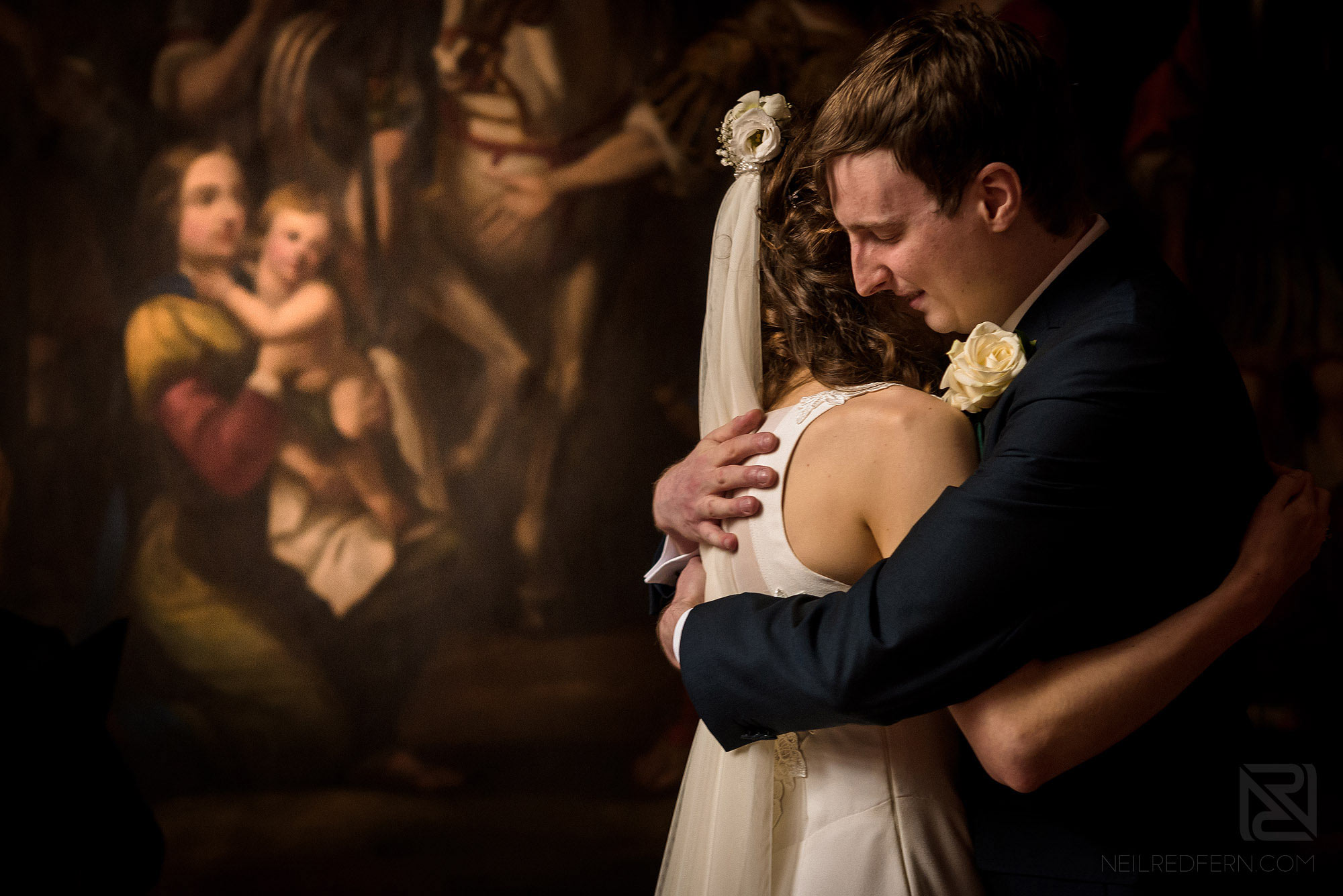 bride and groom hugging each other during wedding ceremony