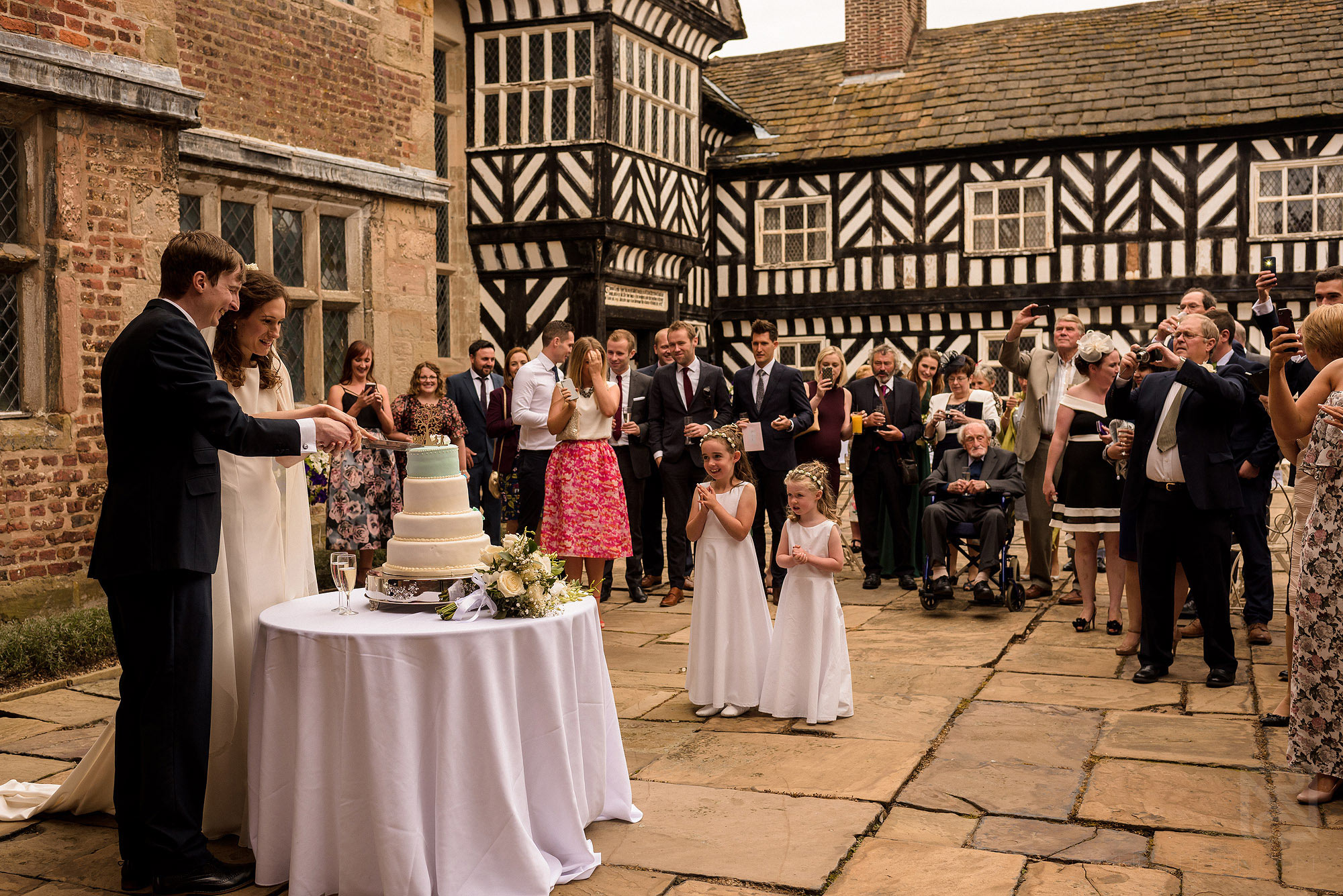 bride and groom cutting cake outside