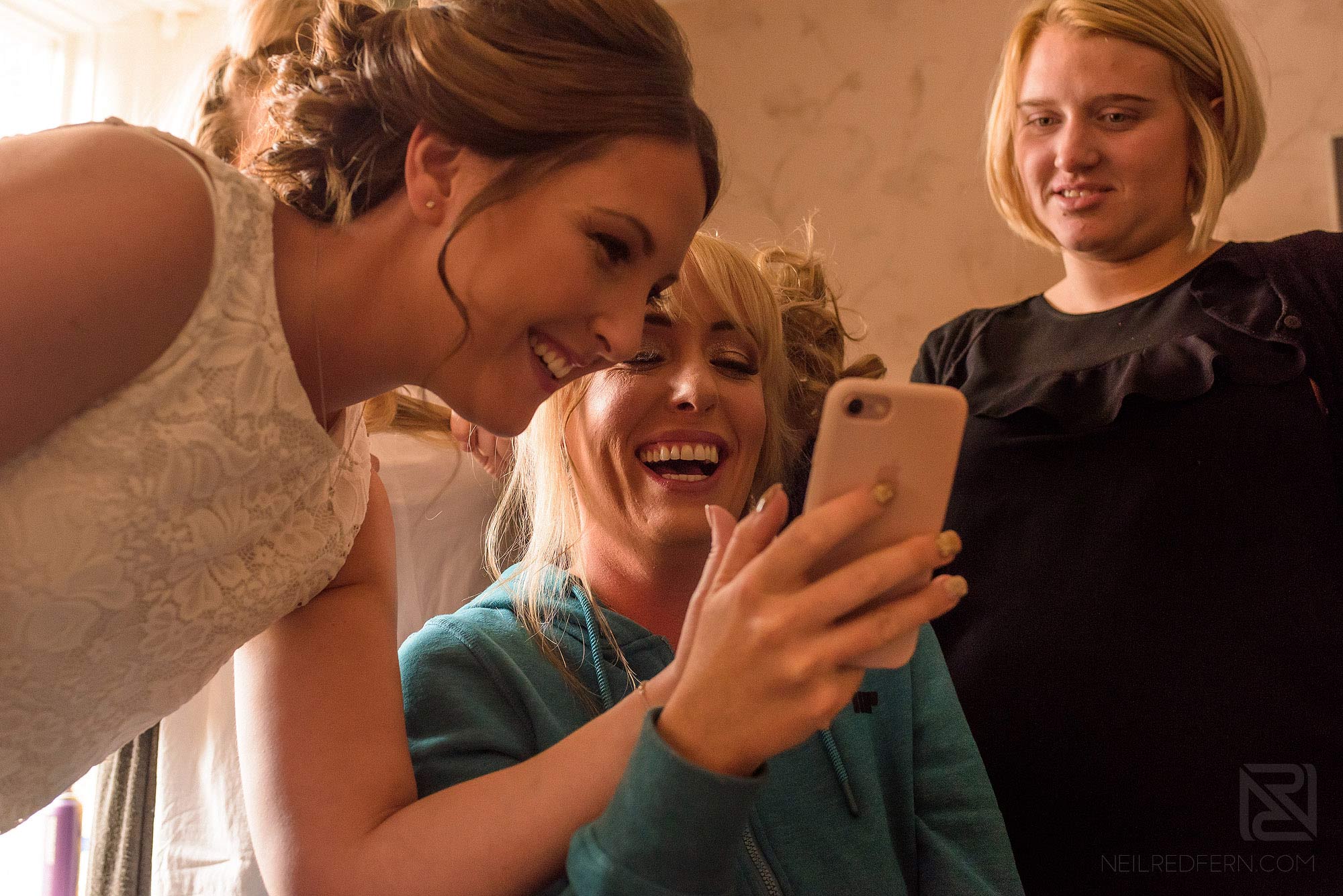 Summer wedding at Arley Hall 2 bride laughing looking at phone