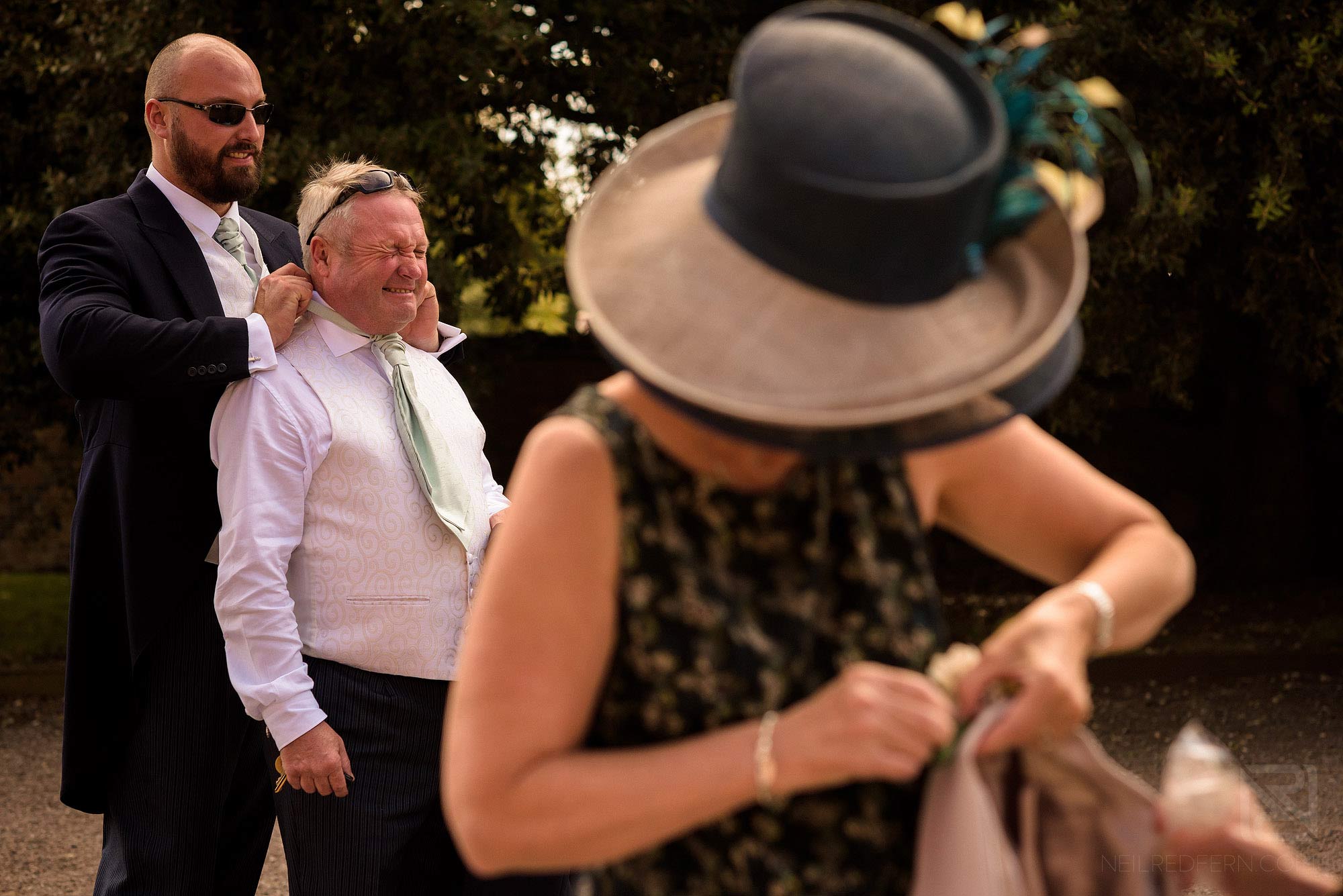 father of groom having tie put on