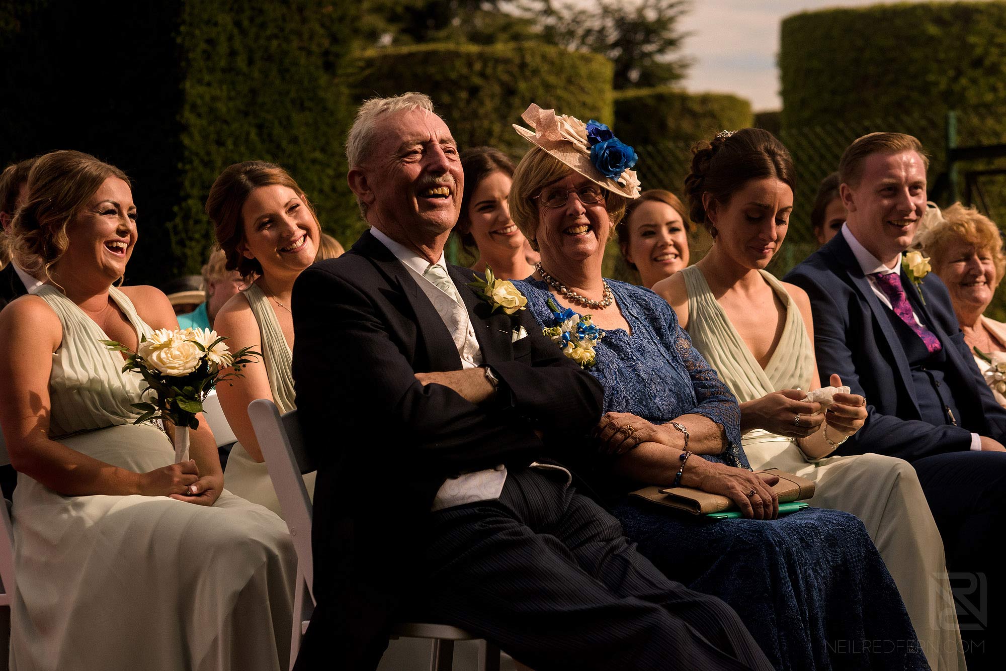 Summer wedding at Arley Hall 14 wedding guests laughing during ceremony