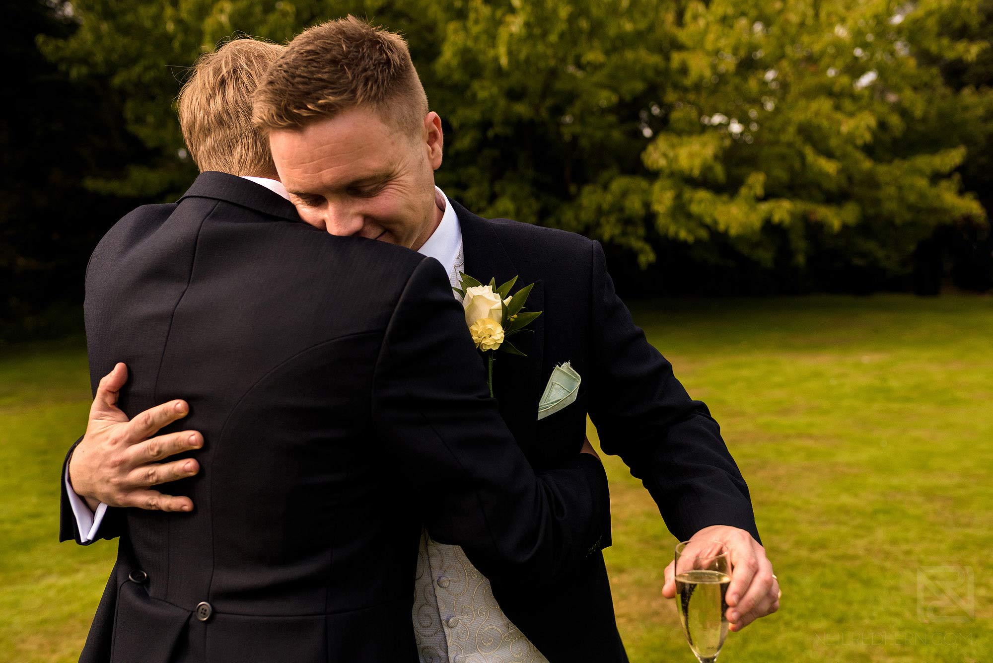 Summer wedding at Arley Hall 19 groom hugging usher