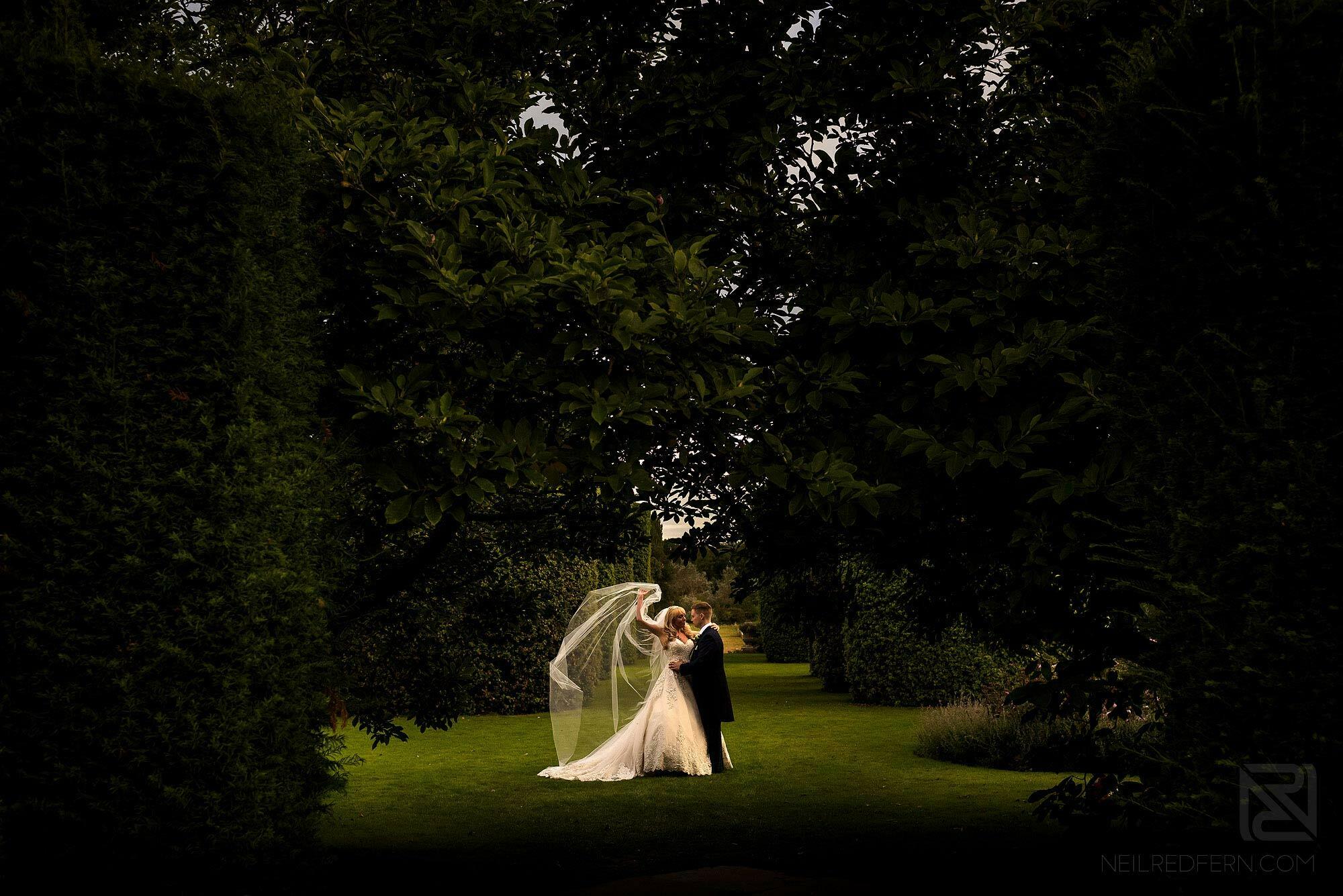 Summer wedding at Arley Hall 25 dramatic photograph of bride and groom with veil blowing in wind