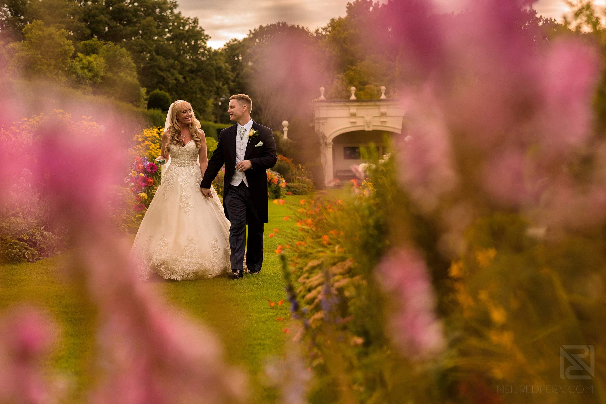 newlyweds walking through Arley Hall gardens