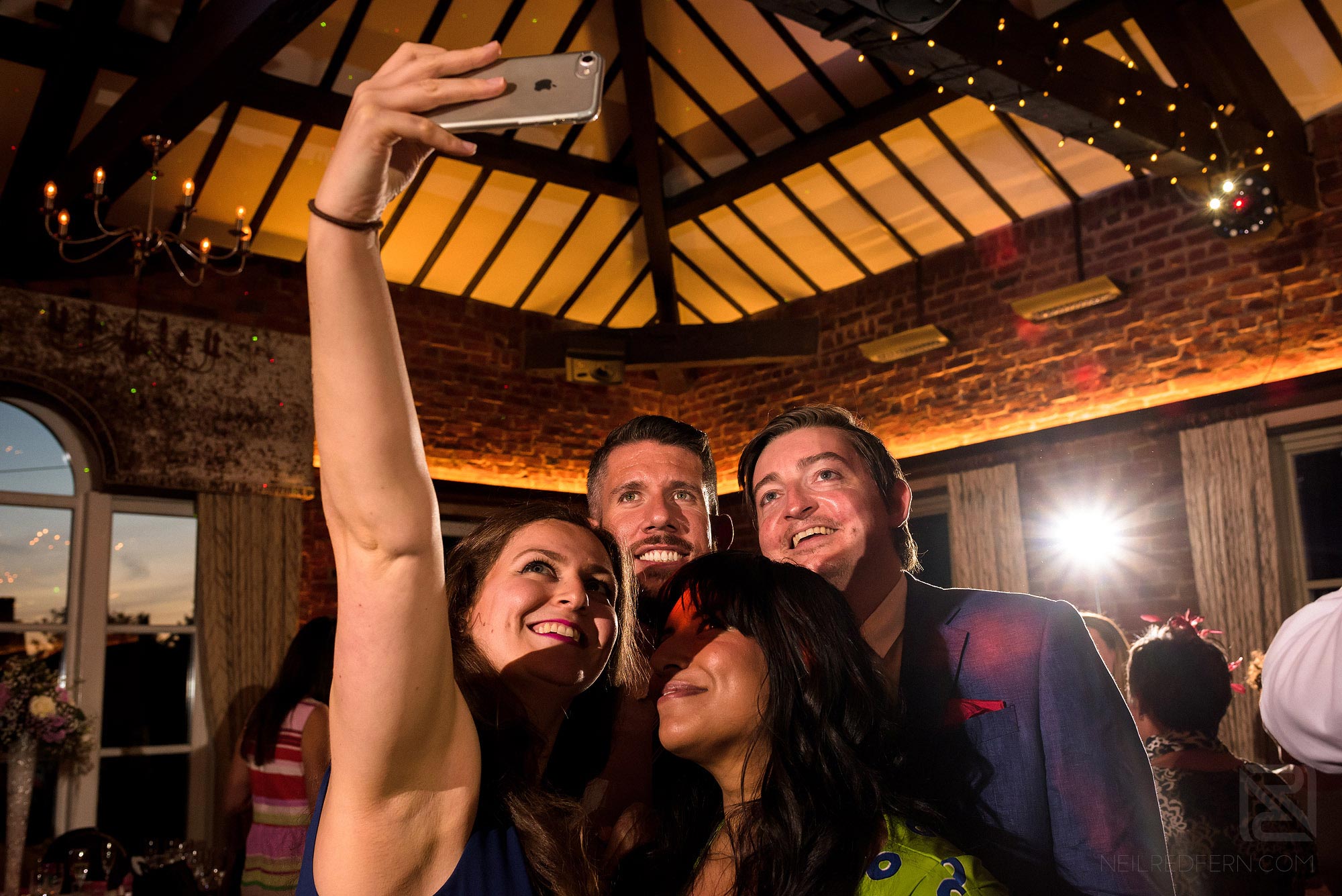 wedding guests taking photographs on dance floor