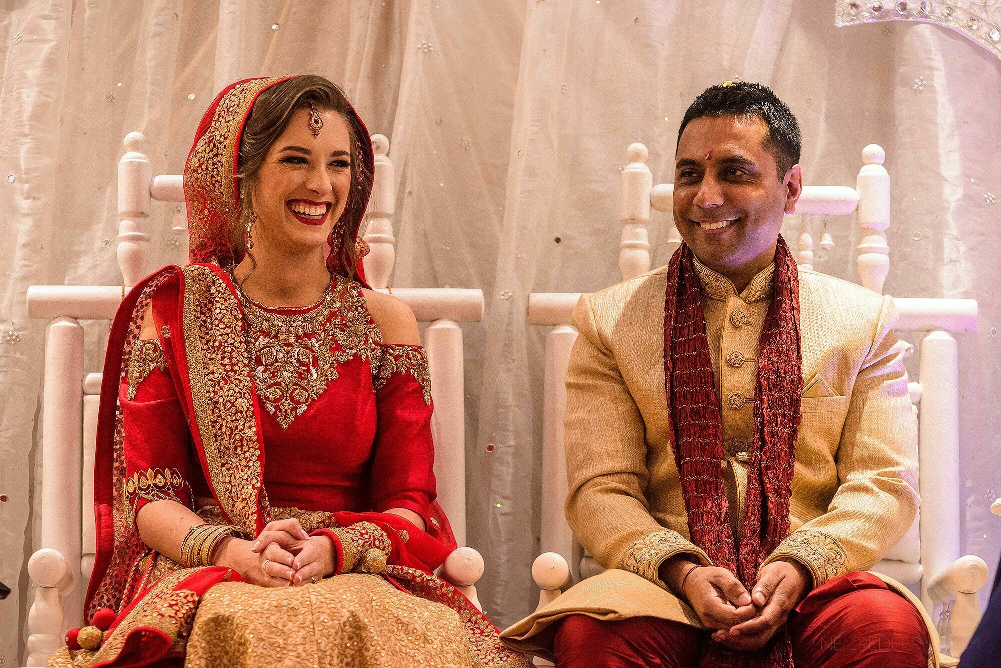 bride and groom laughing under Mandap