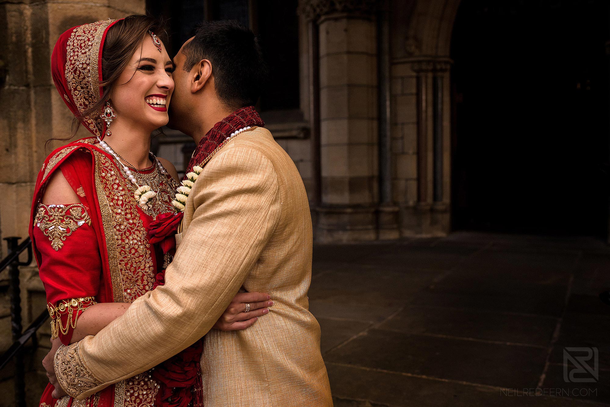 Indian bride and groom laughing outside Rochdale Town Hall