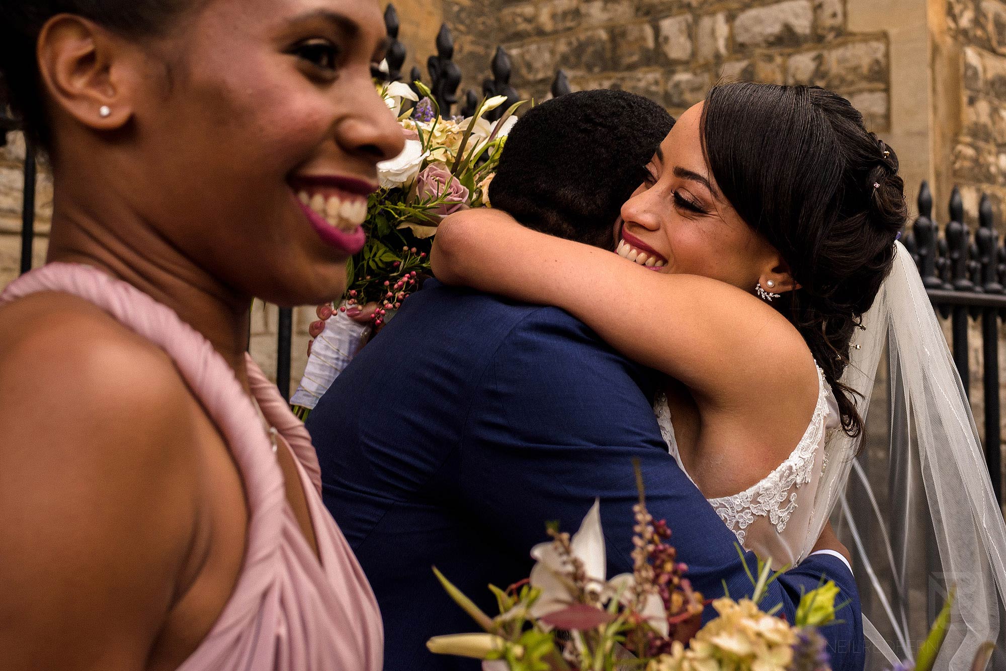 bride hugging friends outside church
