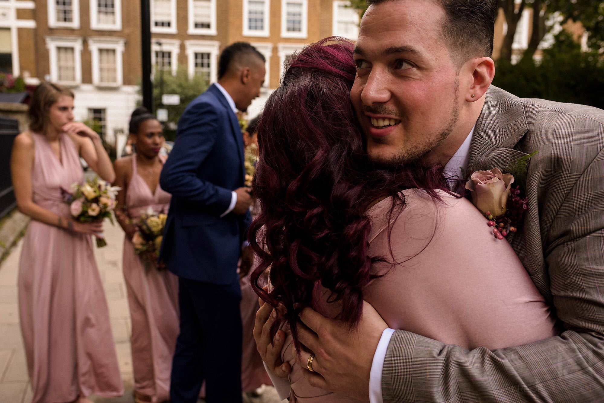 groom hugging friends outside St Mary of the Angels church