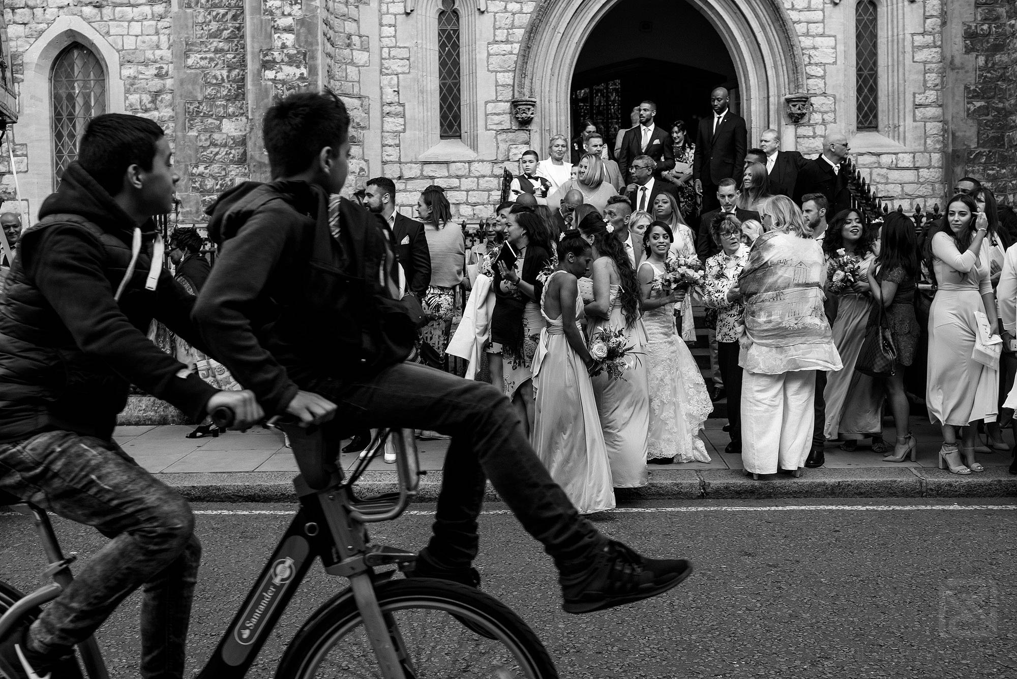 children on bikes passing bridal party