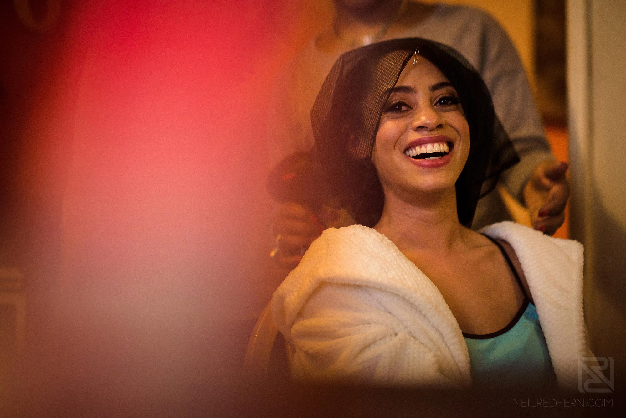 bride laughing as she gets ready