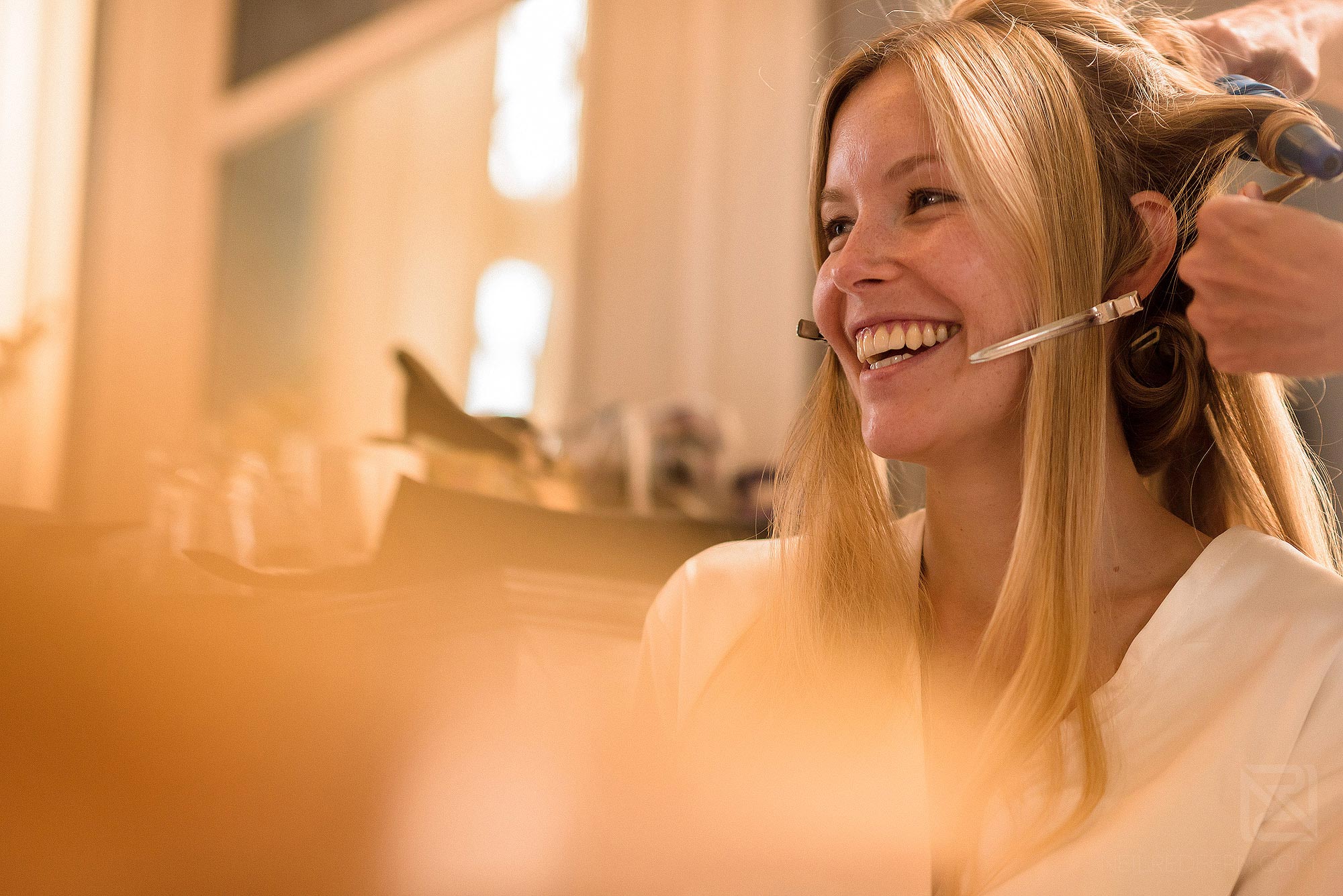 bride smiling as she has make-up put on