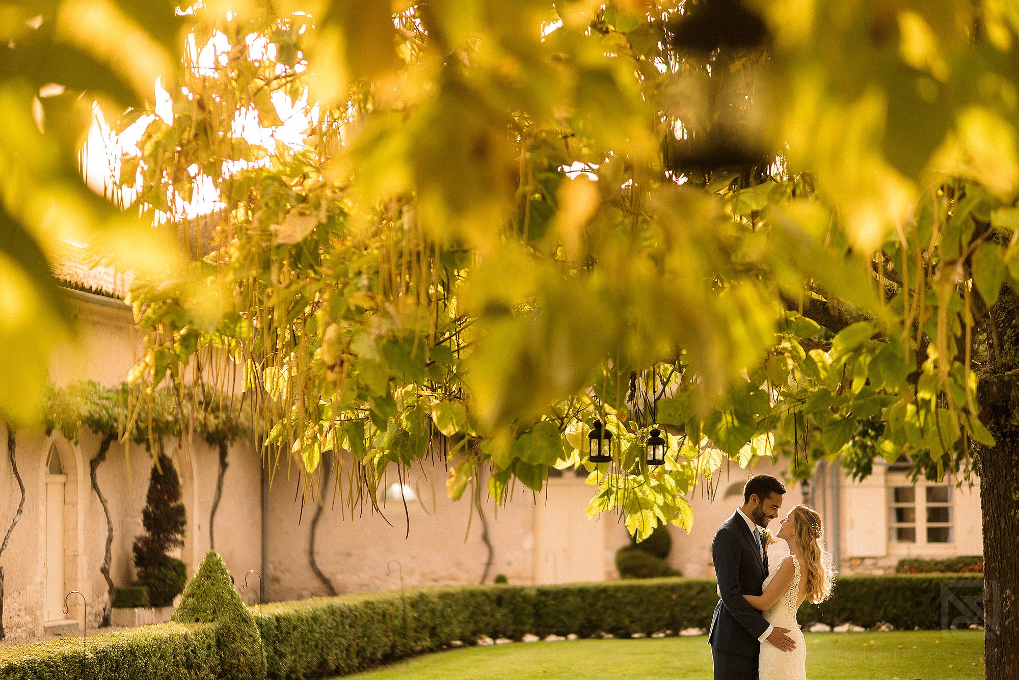 bride and groom stood in beautiful light in gardens of Chateau Soulac