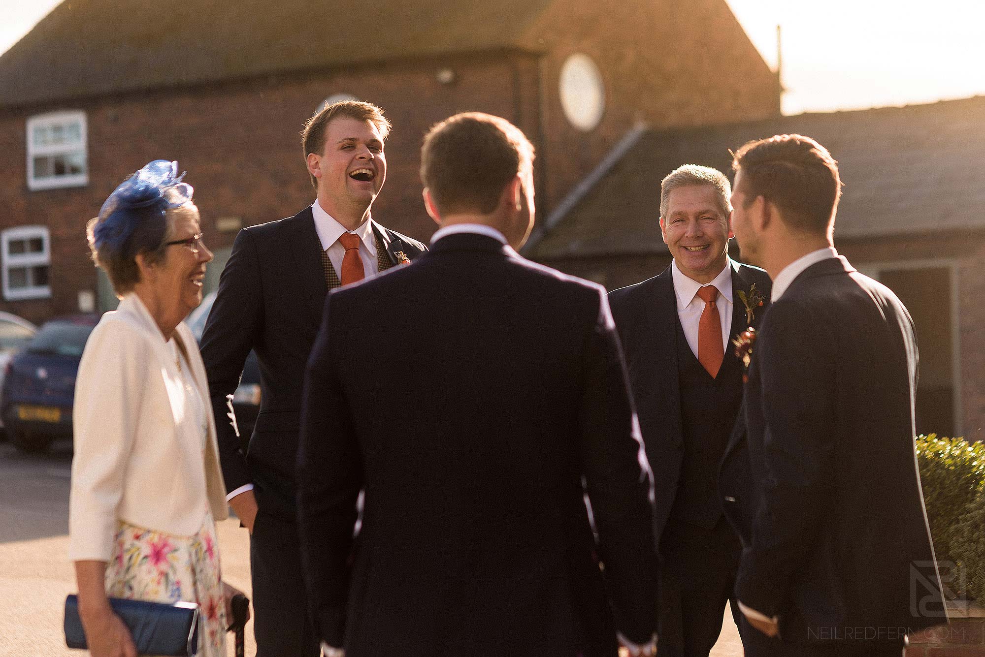 groom laughing with friends at Sandhole Oak Barn wedding