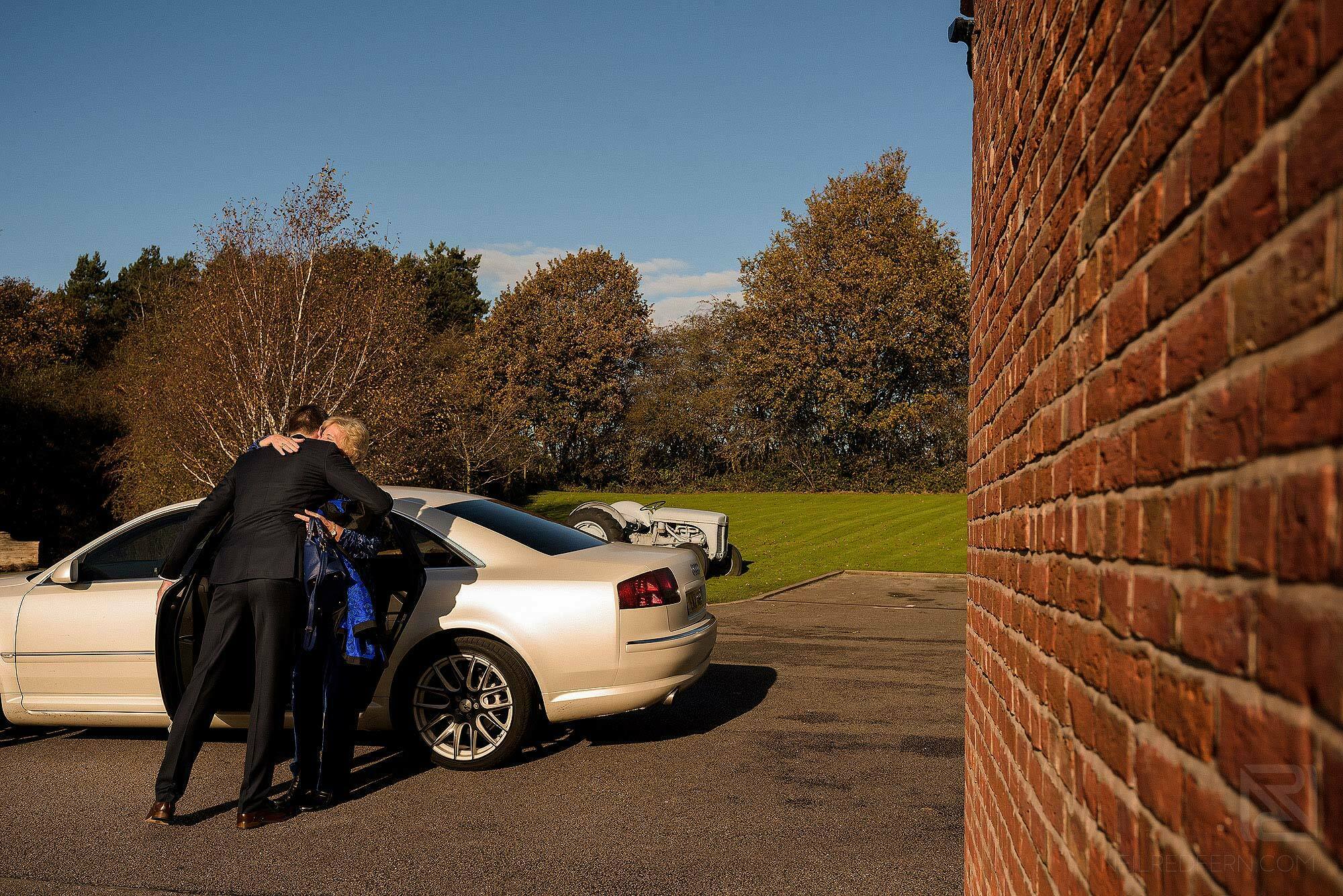 groom hugging friend getting out of car