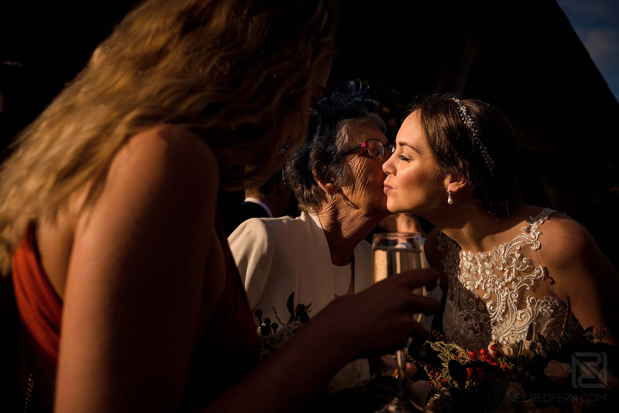 bride kissing friend during drinks reception