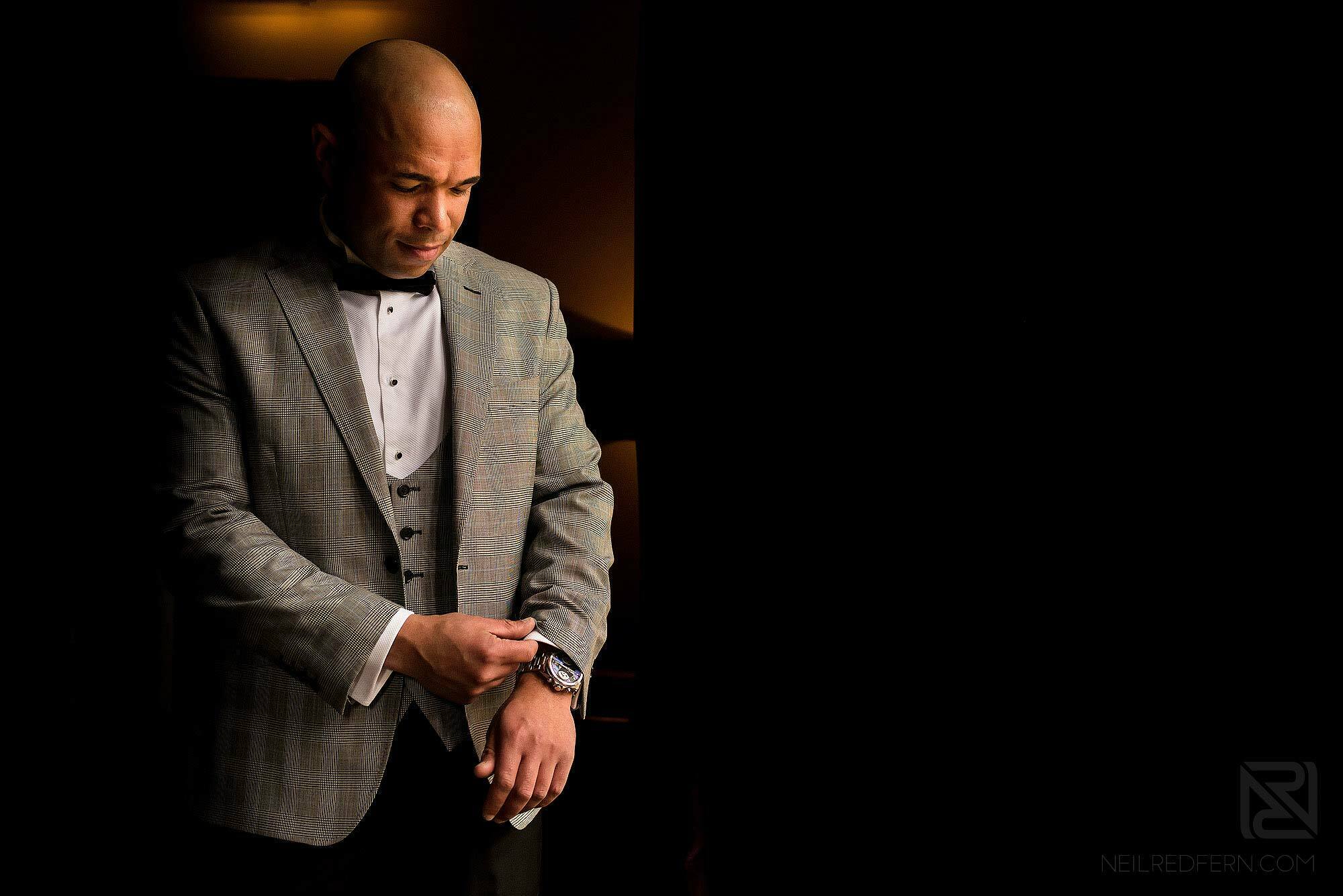 groom putting suit on at wedding