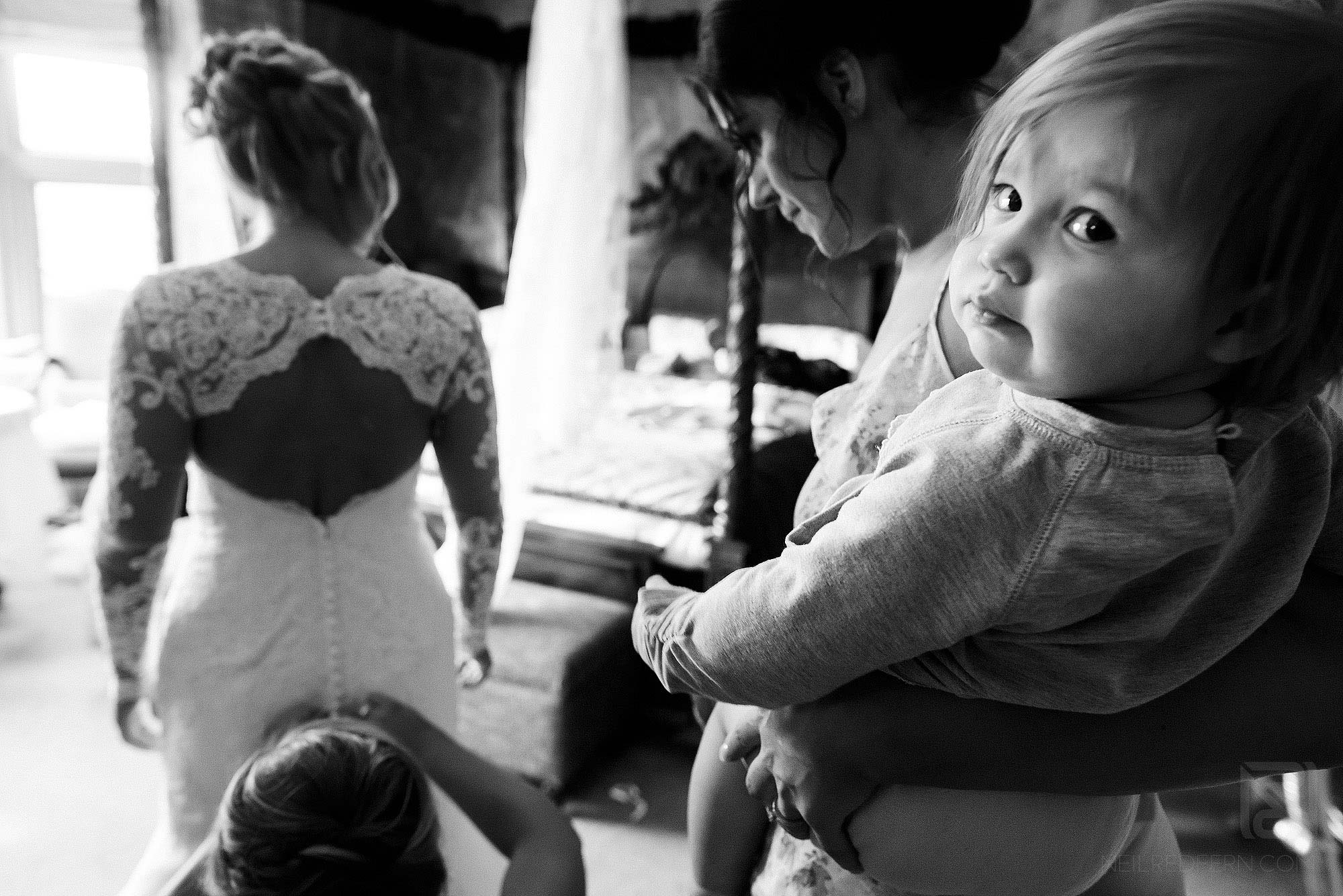 reportage photograph of bride putting on wedding dress