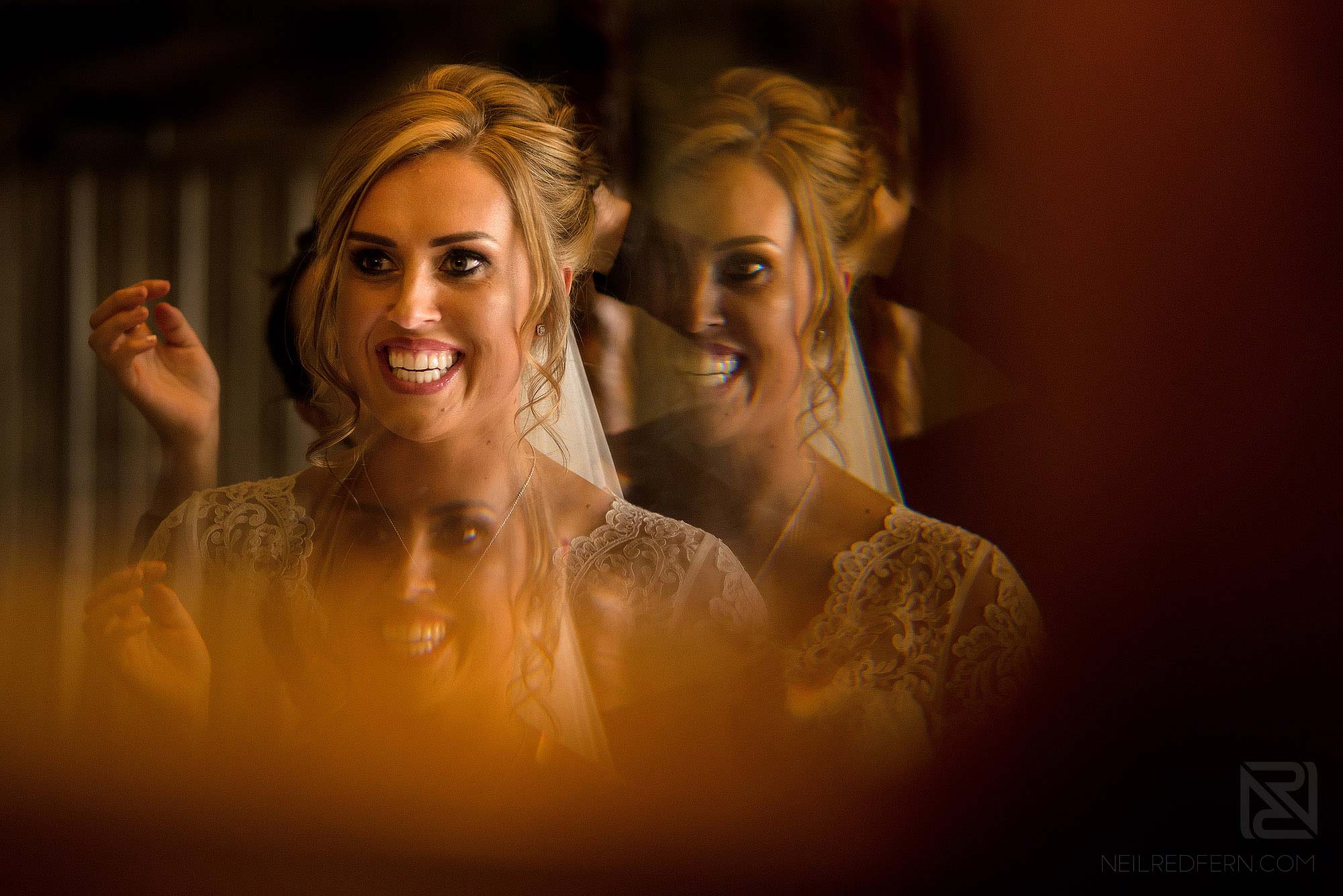 creative photograph of smiling bride in mirror