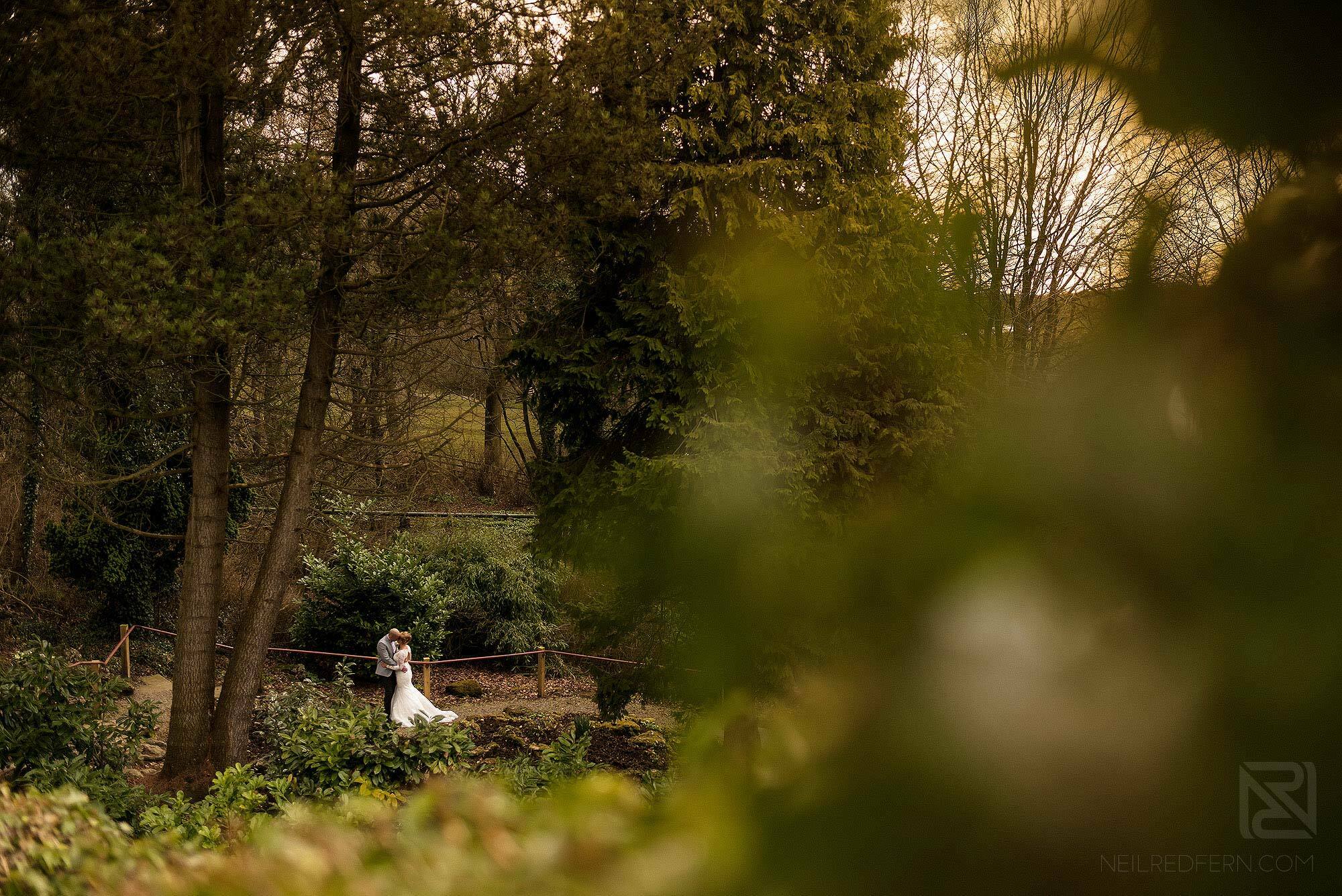 wide angle photograph of newlyweds in Mitton Hall gardens