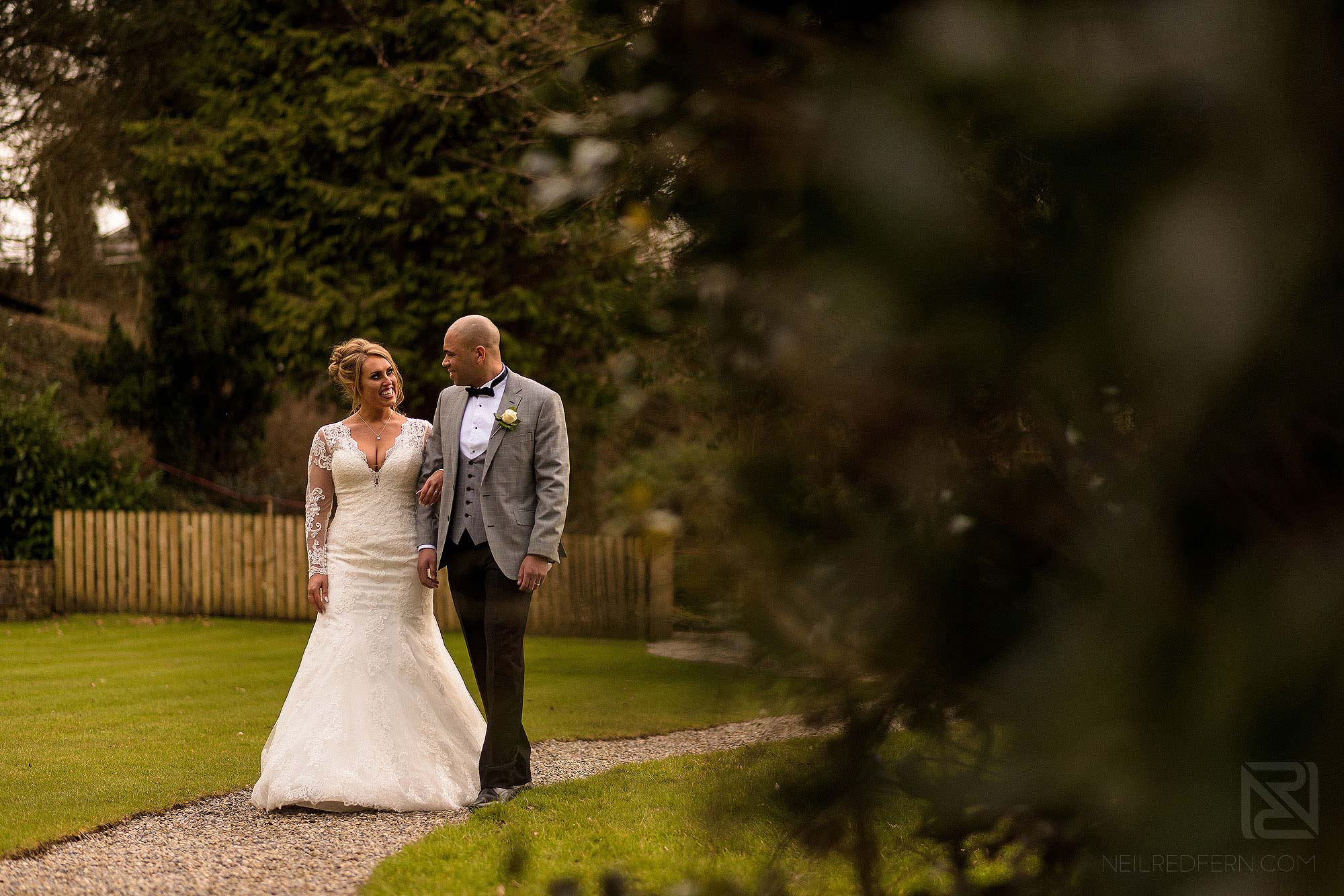 bride and groom walking through grounds at Mitton Hall