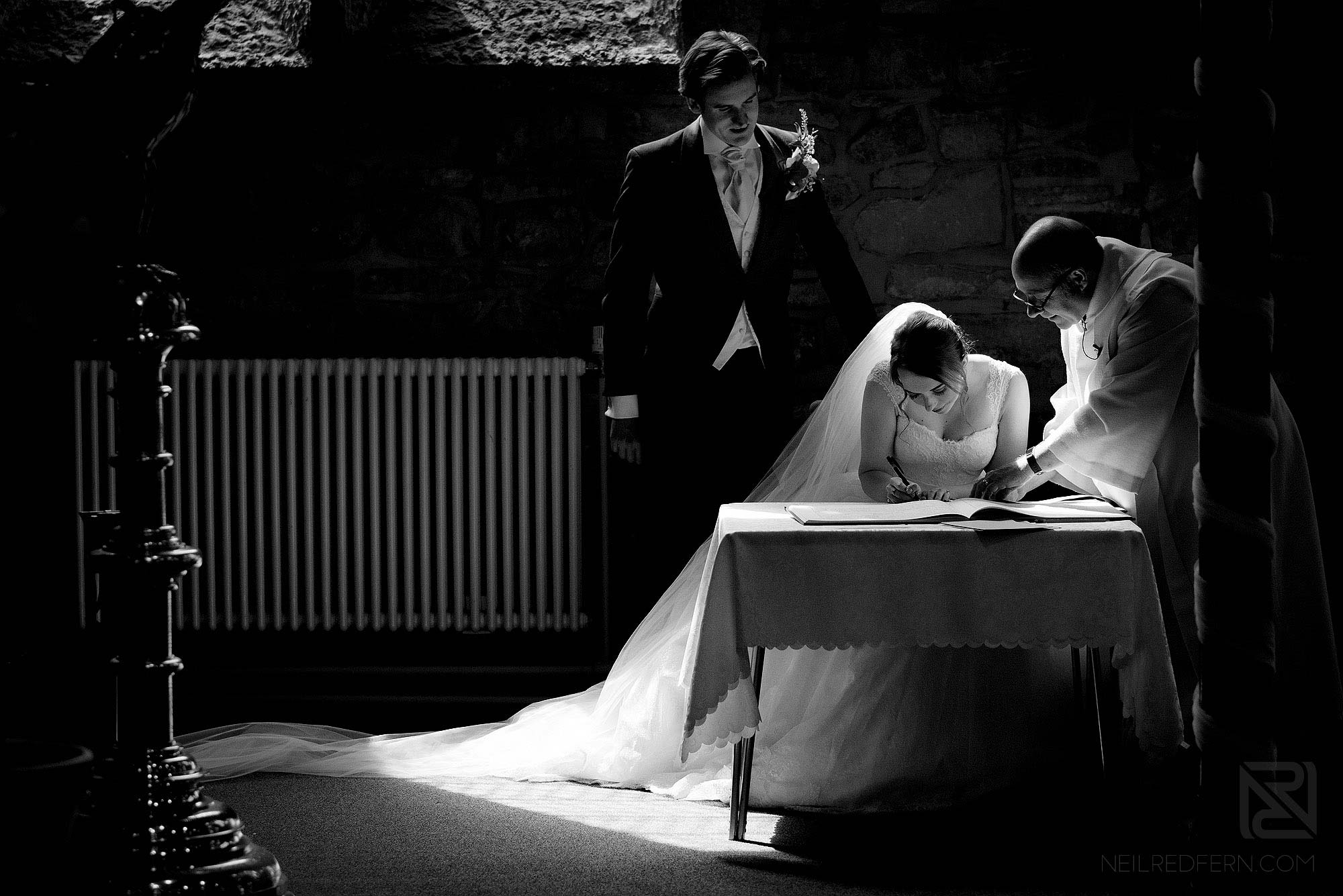 bride signing wedding register in church