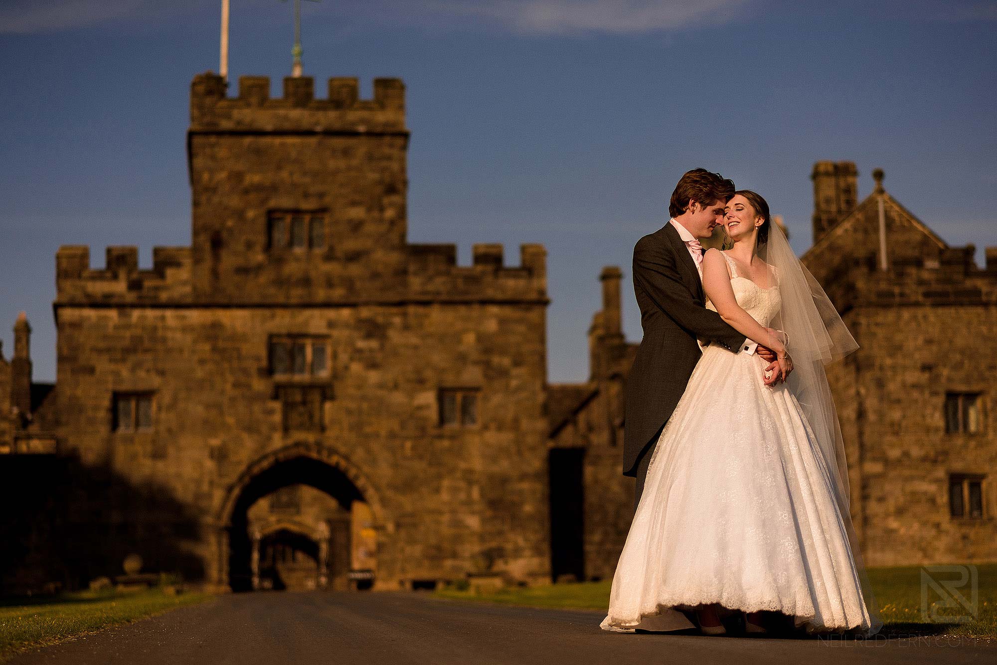 bride and groom outside Hoghton Tower at sunset
