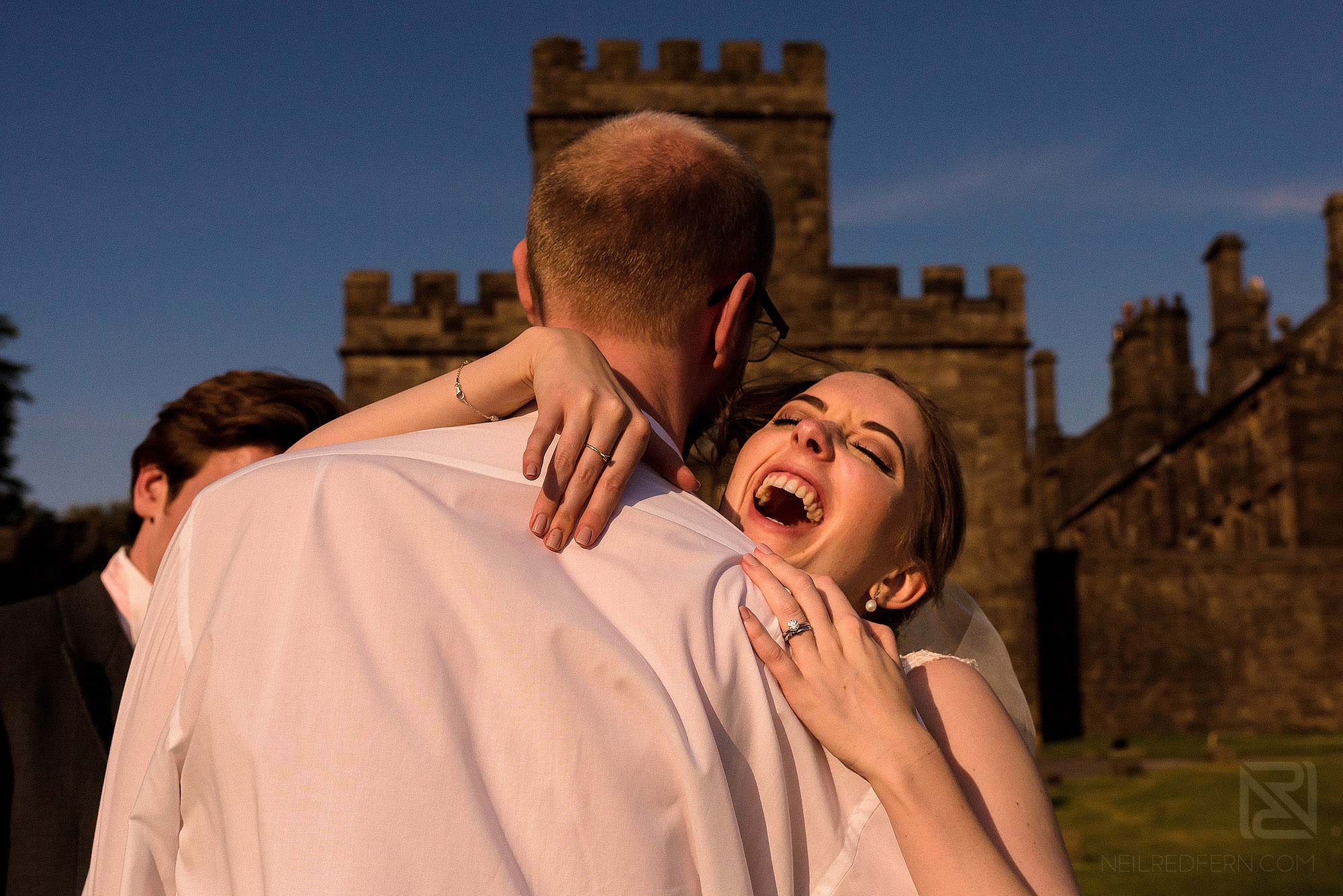 bride laughing with wedding guest outside Hoghton Tower
