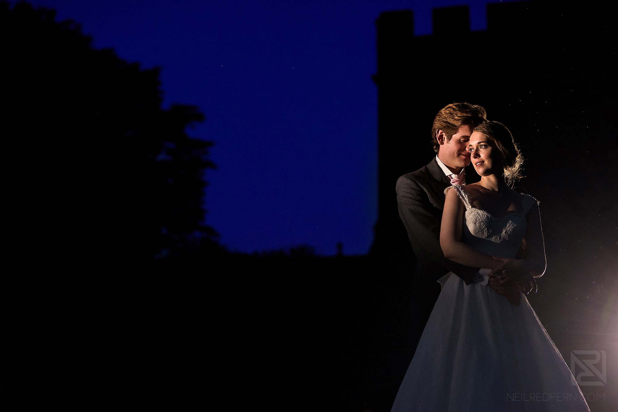 night time portrait of bride and groom outside Hoghton Tower at night