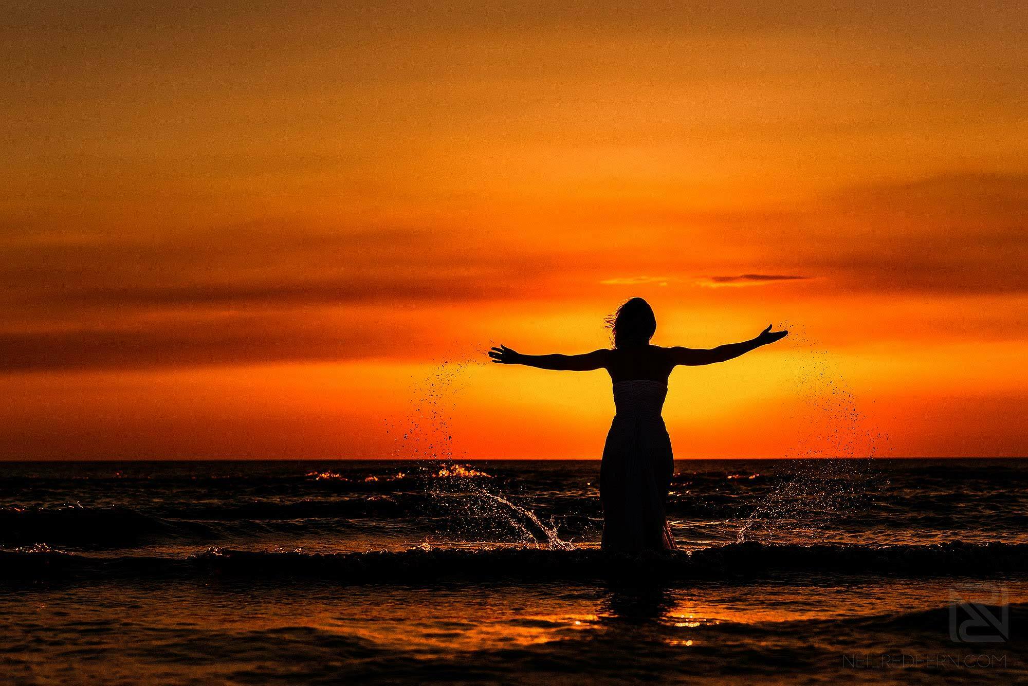 Trash the dress shoot on the beach 3 silhouette photograph of bride in the sea