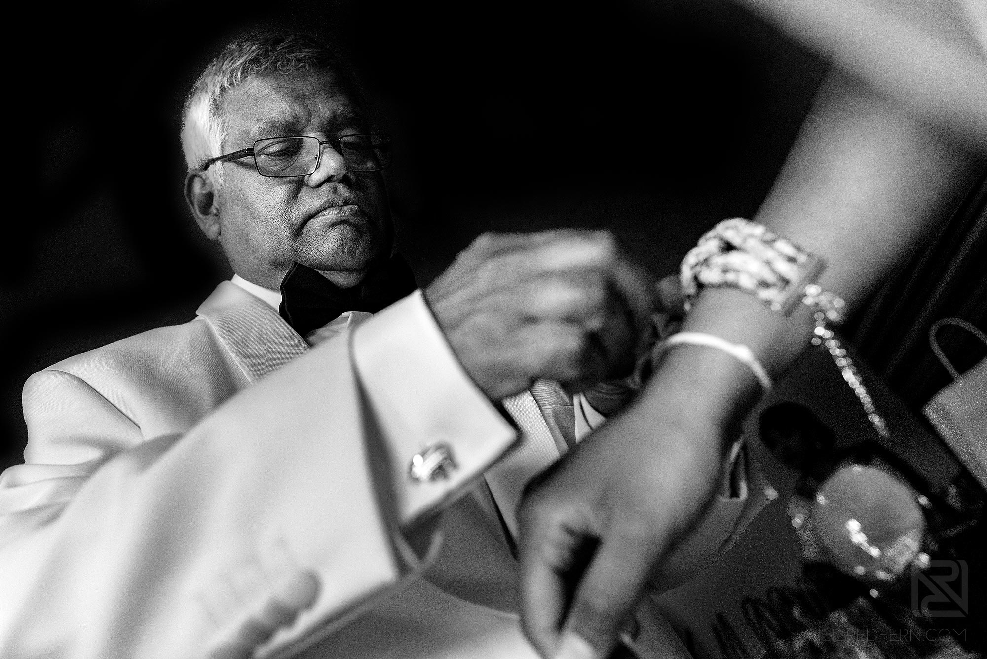 father of bride helping bride get ready