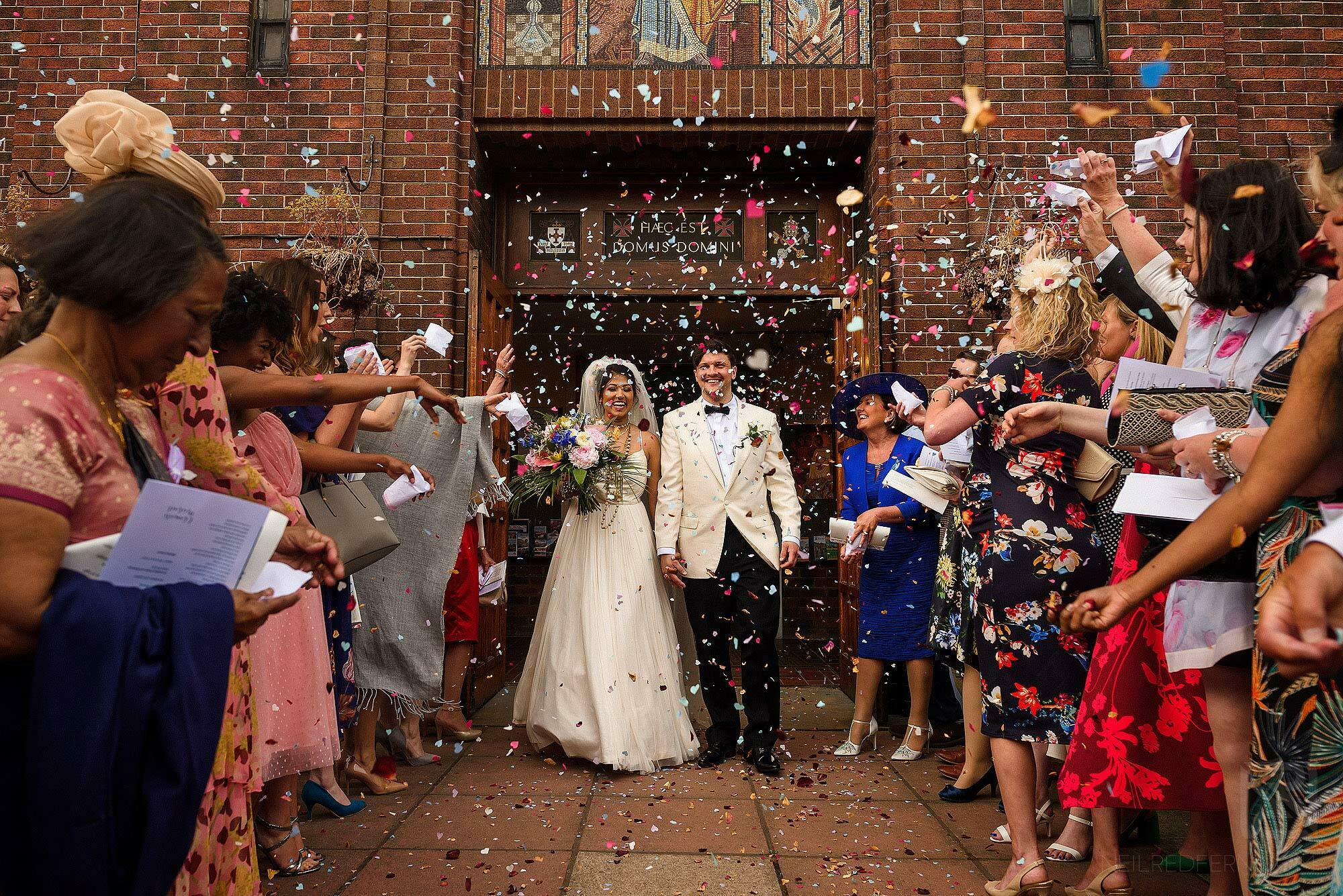 bride and groom walking through confetti