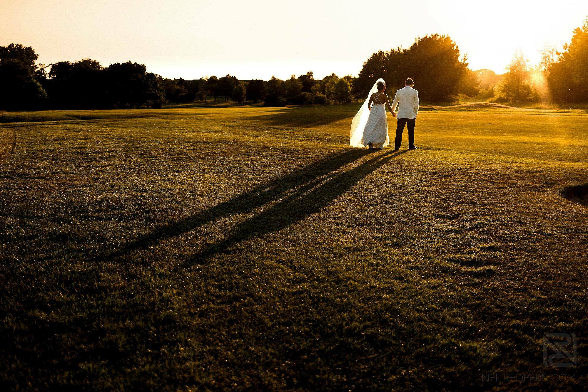 bride and groom walking in to the sunset