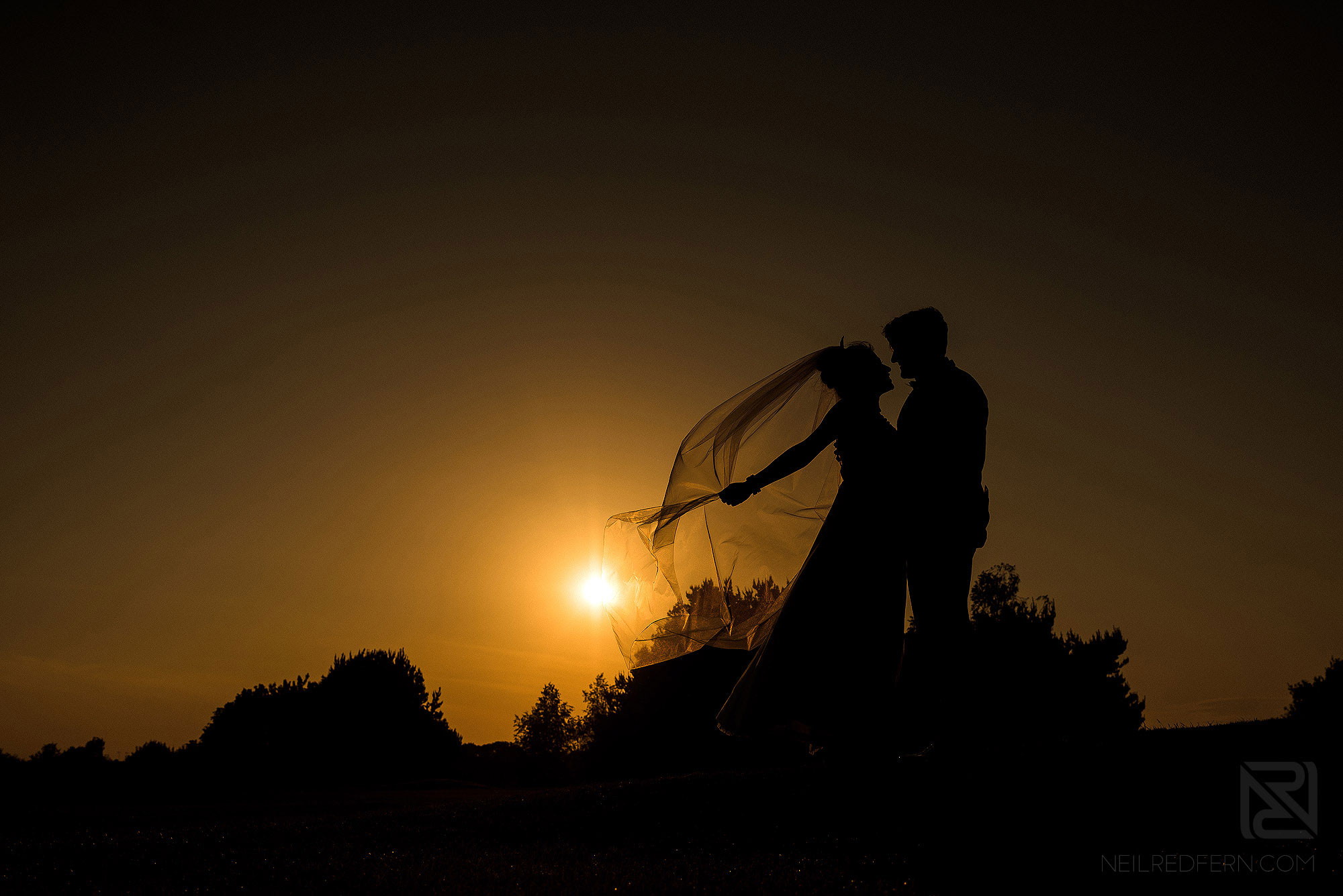 silhouette portrait of bride and groom at sunset
