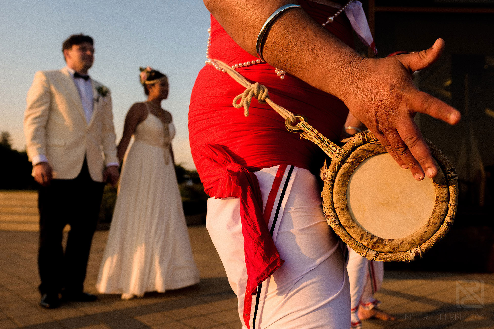 bride and groom following Sri Lankan dancers