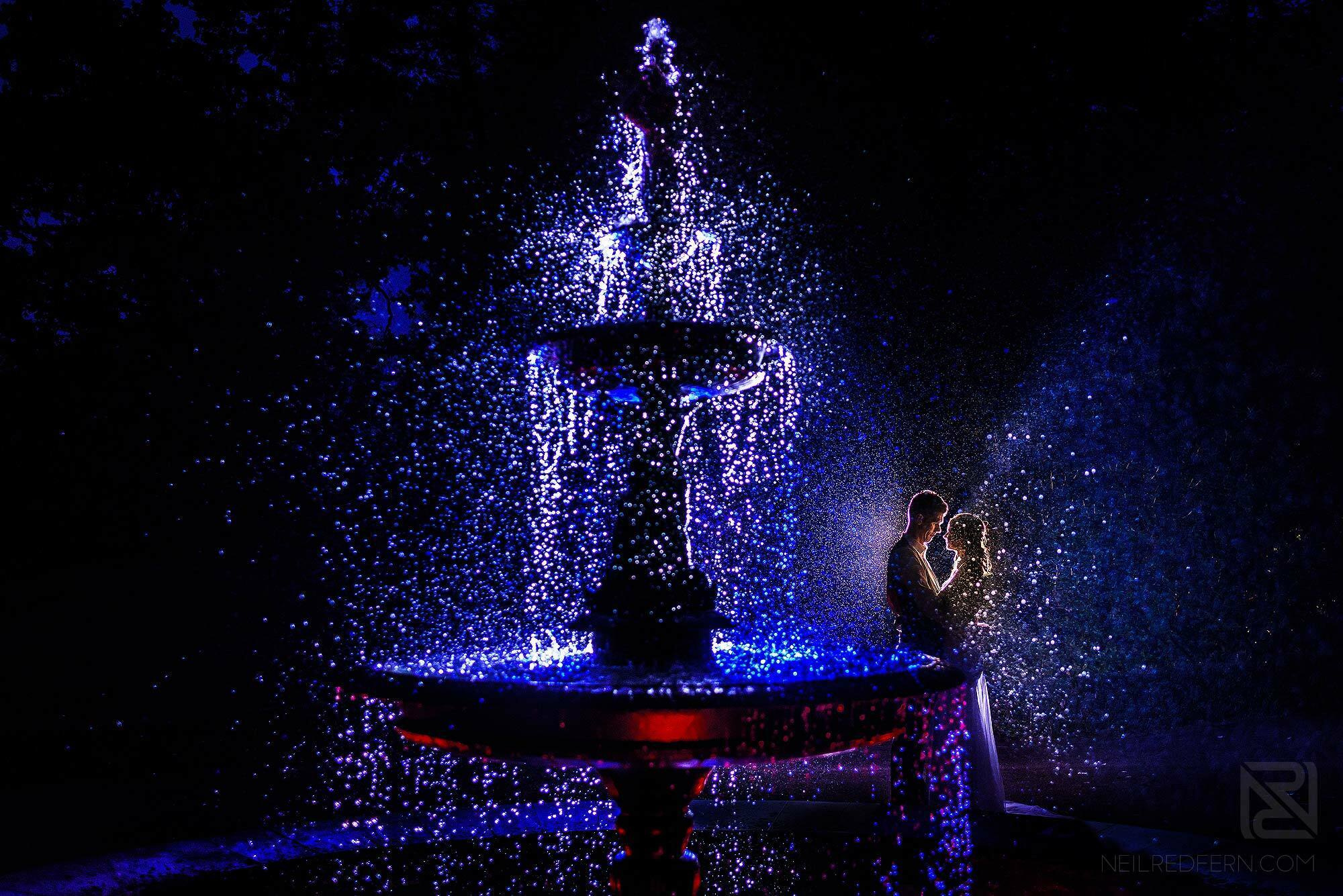 creative OCF portrait of bride and groom with fountain