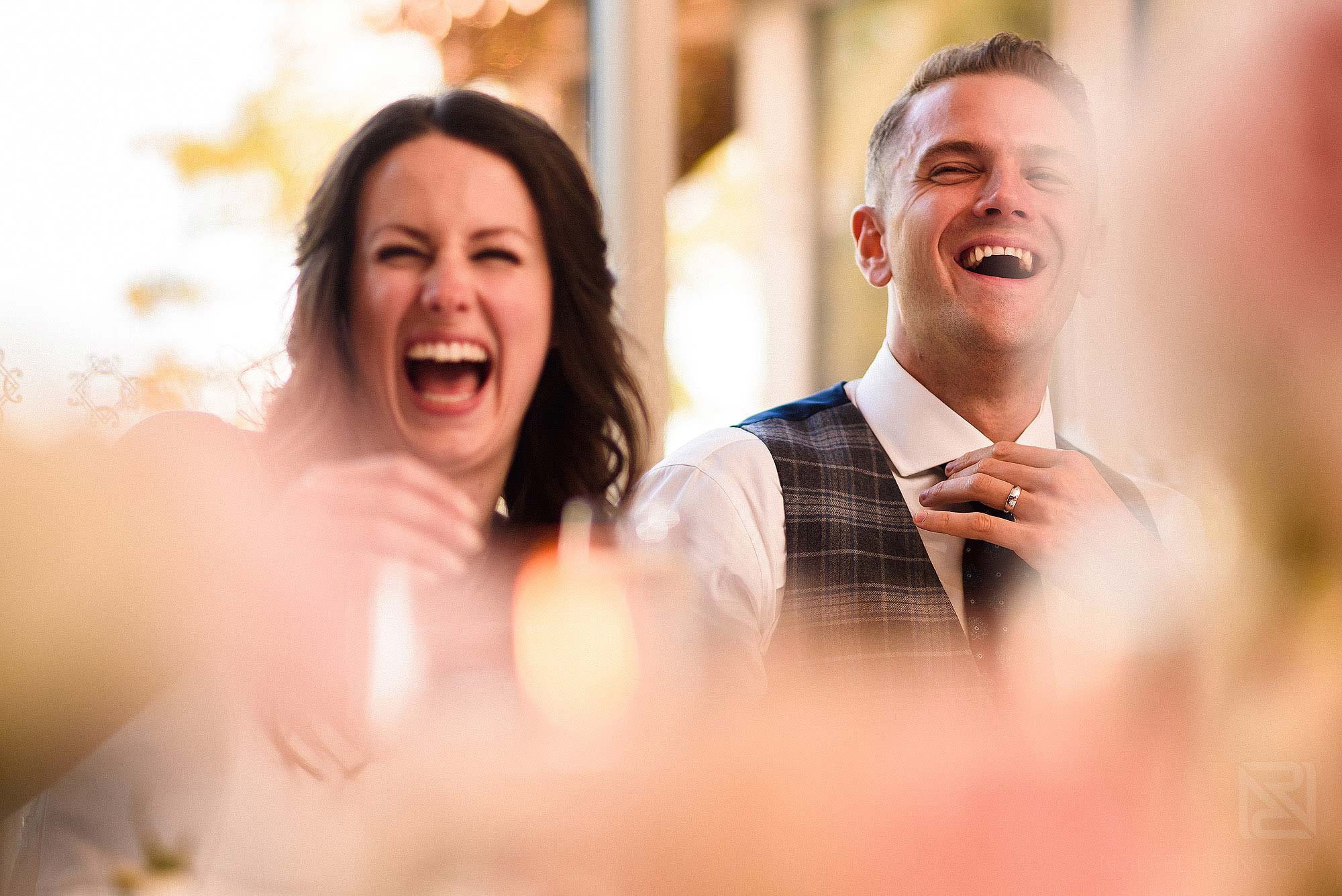 bride and groom laughing during wedding speeches