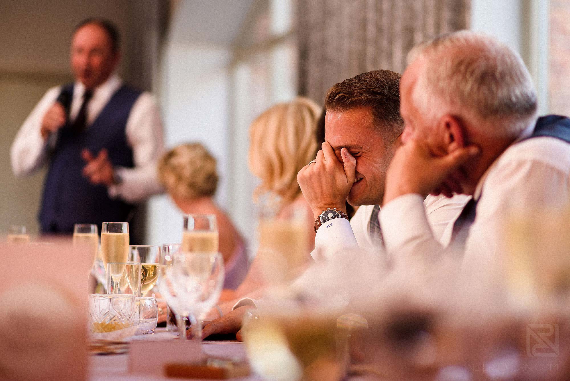 groom laughing during wedding speeches