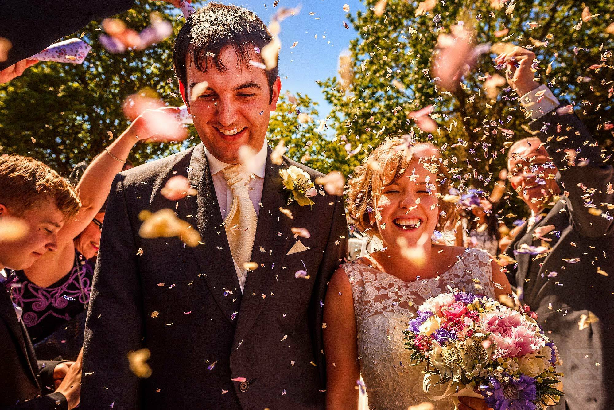 bride and groom walking through confetti