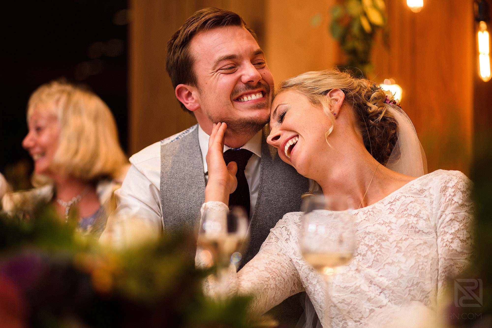 bride and groom laughing during wedding speeches