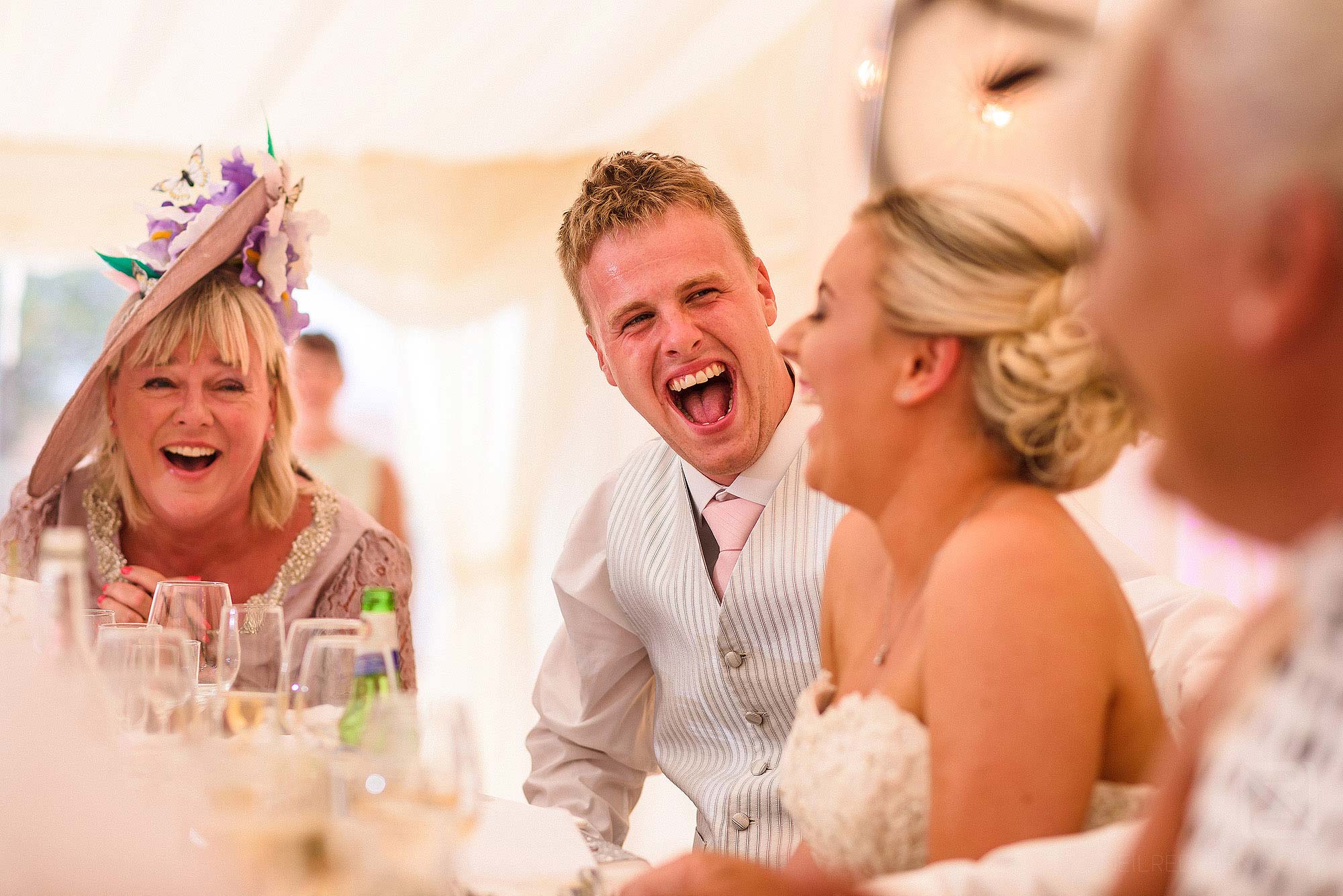 groom laughing during wedding speeches