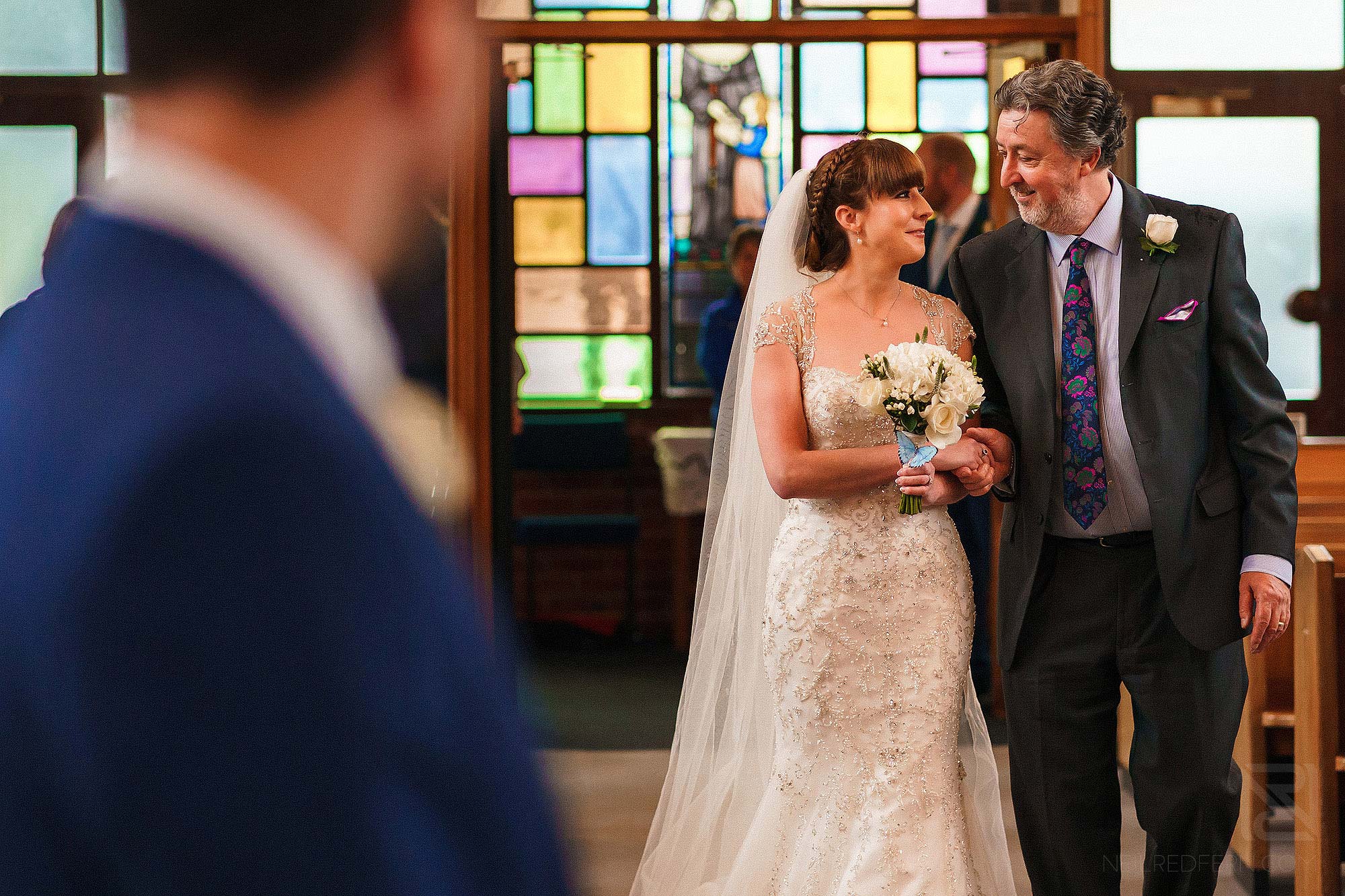 bride and father looking at each other walking down the aisle