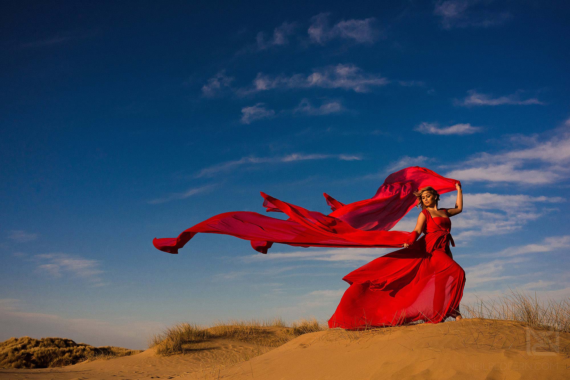 bride with long red dress on the beach at Formby