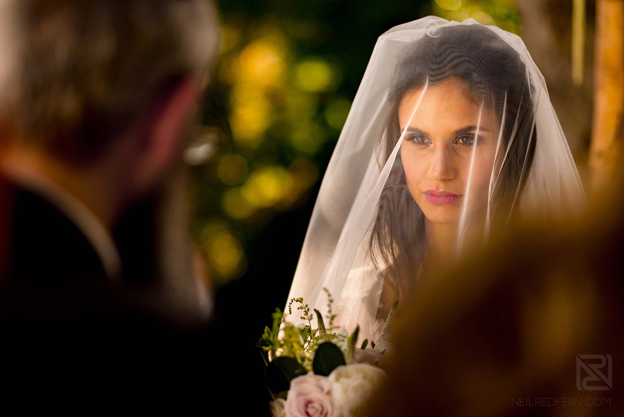 Jewish bride looking at Rabbi during wedding ceremony