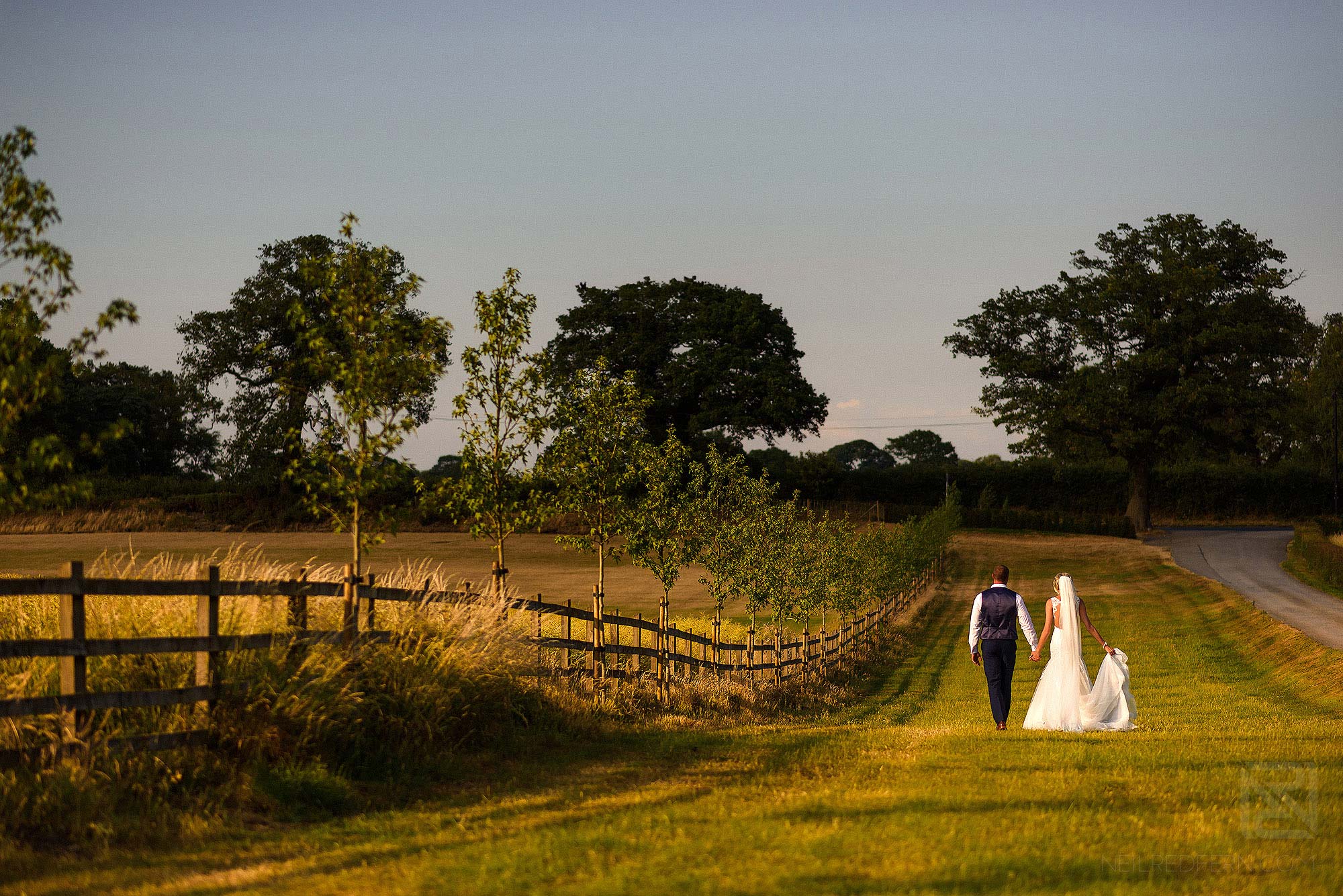 wide angle photograph of bride and groom at Sandhole Oak Barn